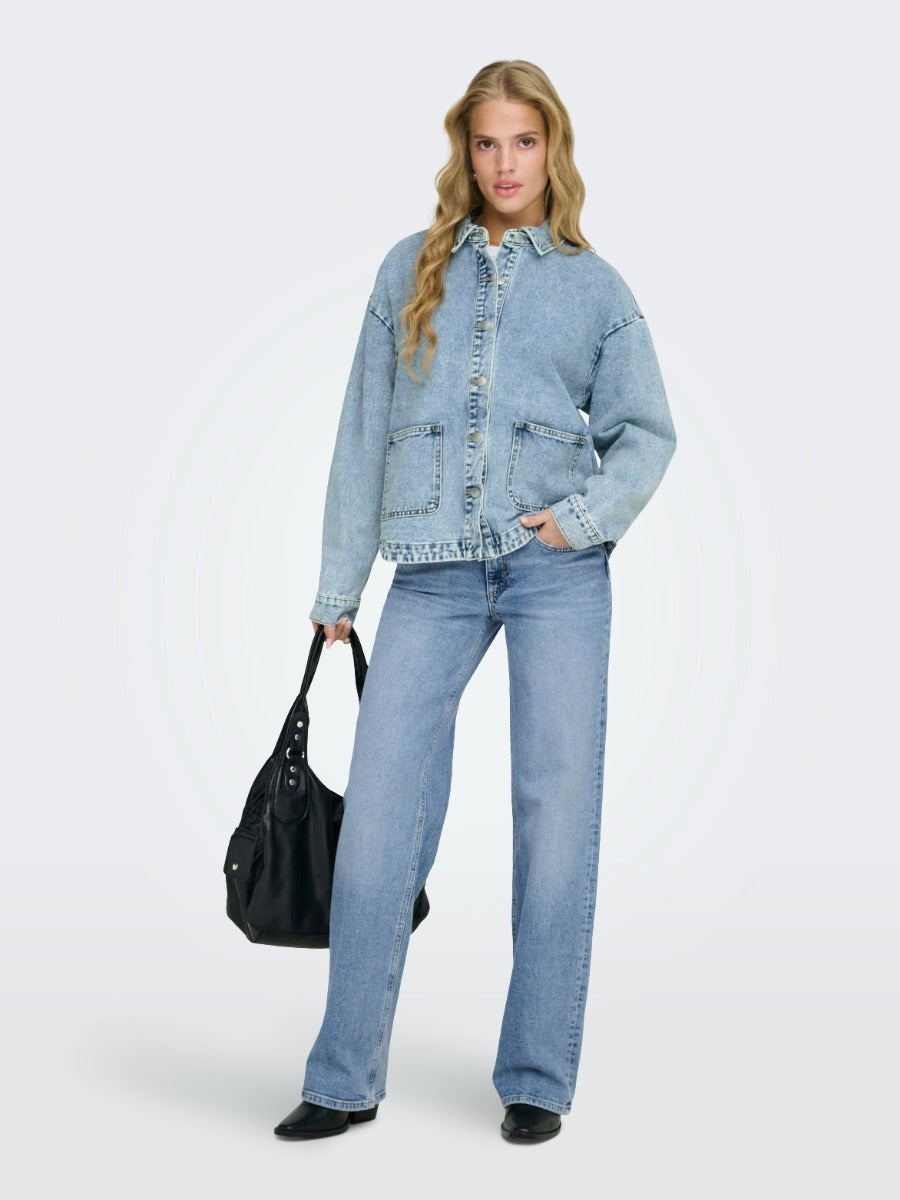 ONLY Ferbie Women’s Double Pocket Denim Jacket by Only in light blue denim, styled with wide-leg jeans and black accessories.