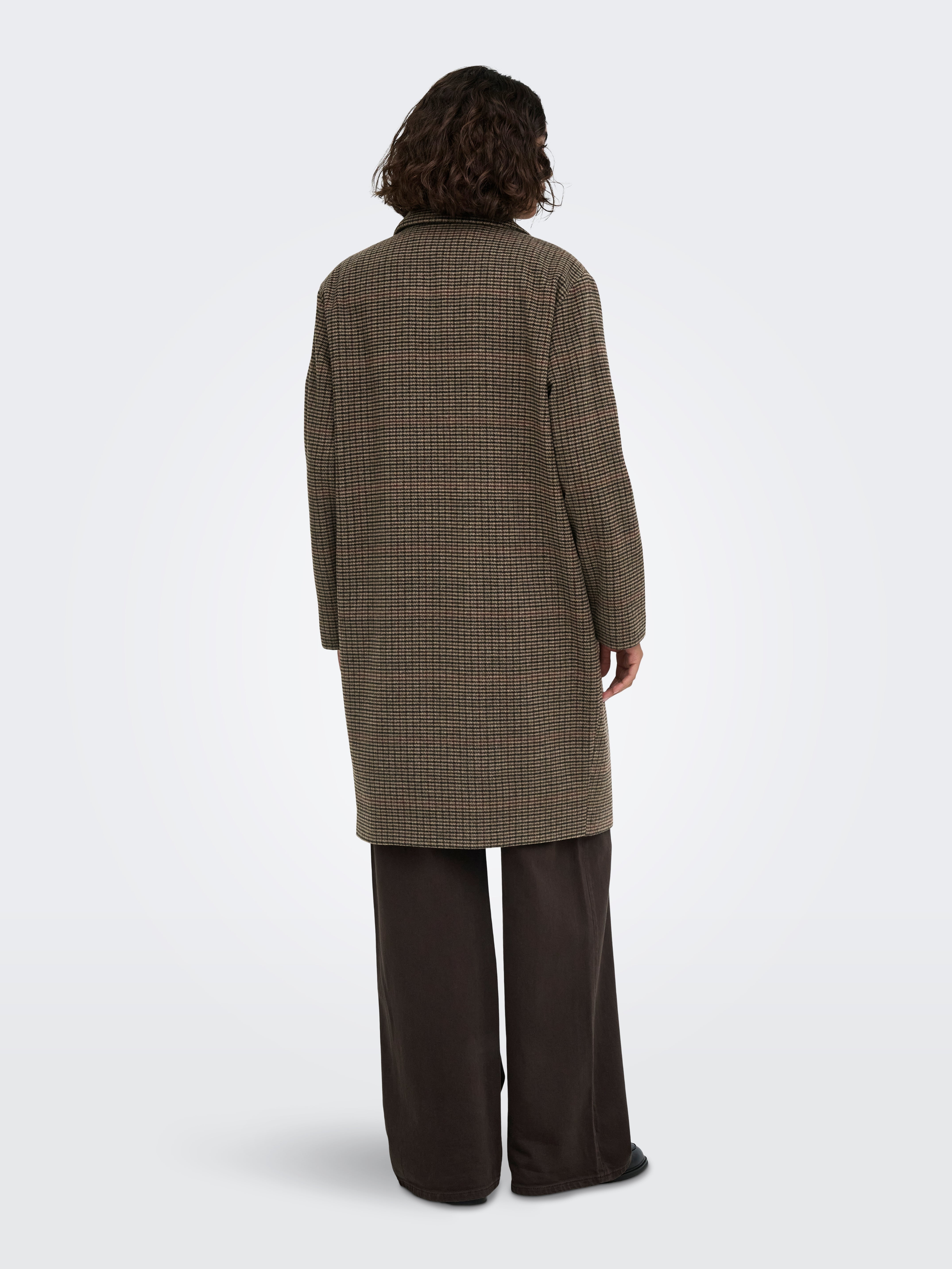Back view of a knee-length checked coat paired with wide-legged dark trousers against a plain background.