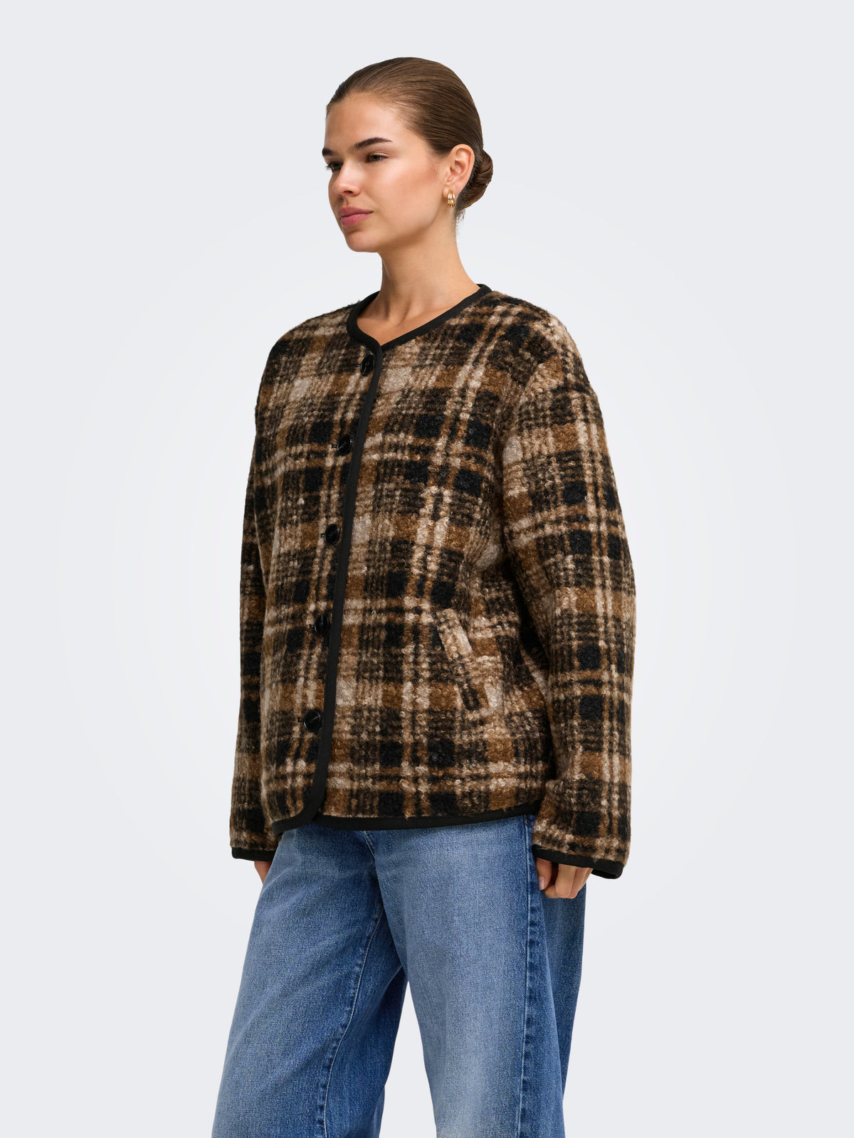 Brown and black plaid jacket with front buttons and pockets, paired with blue jeans against a light background