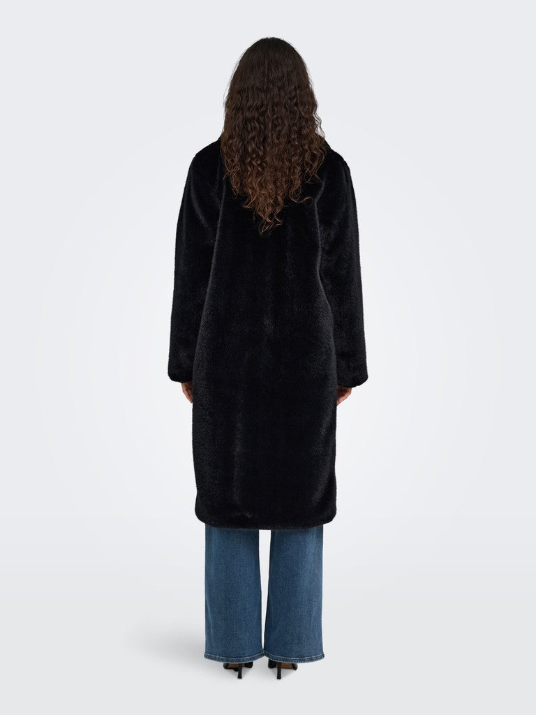 Back view of a long black textured coat with blue jeans