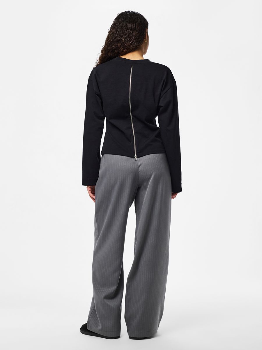Black Amy Back Zip Long Sleeve Top by Pieces with visible back zipper detail paired with gray wide-leg pants