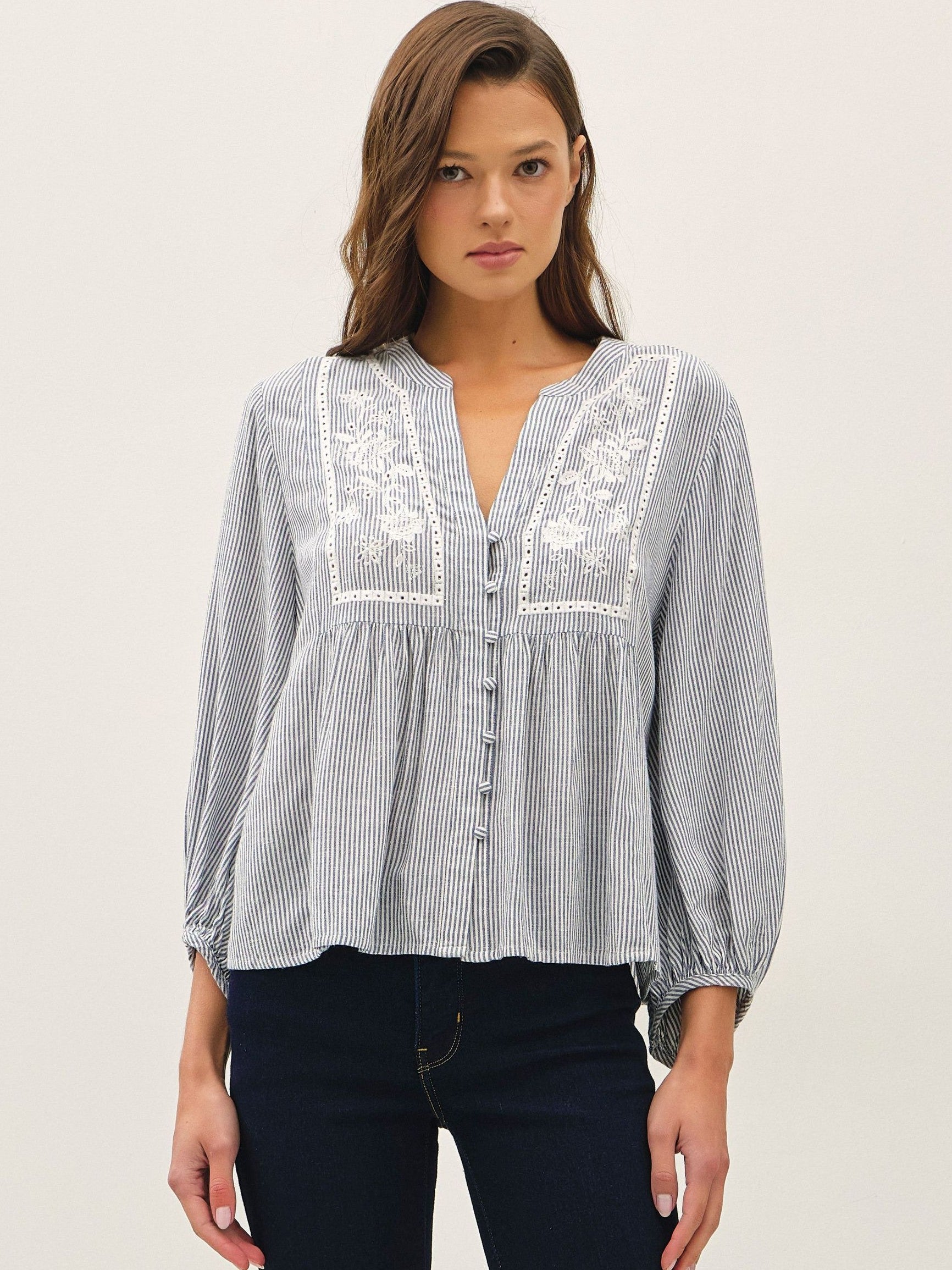 Be Cool Stripe Embroidered Button-Up Blouse in blue striped fabric with floral embroidery and long sleeves, styled with dark denim.