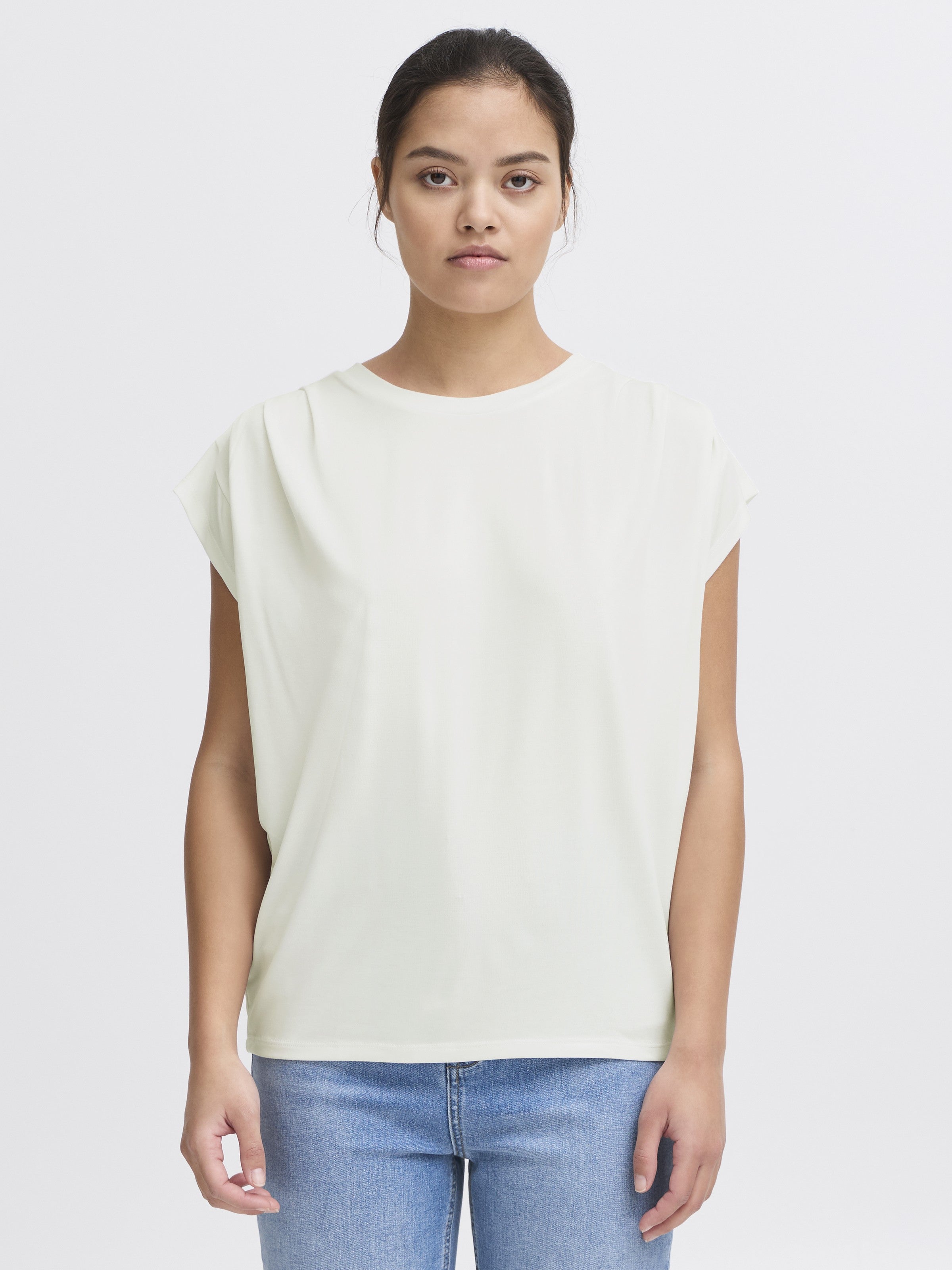 Ichi Lisken Top in white by Ichi, sleeveless casual top paired with blue denim jeans for a minimalist look.