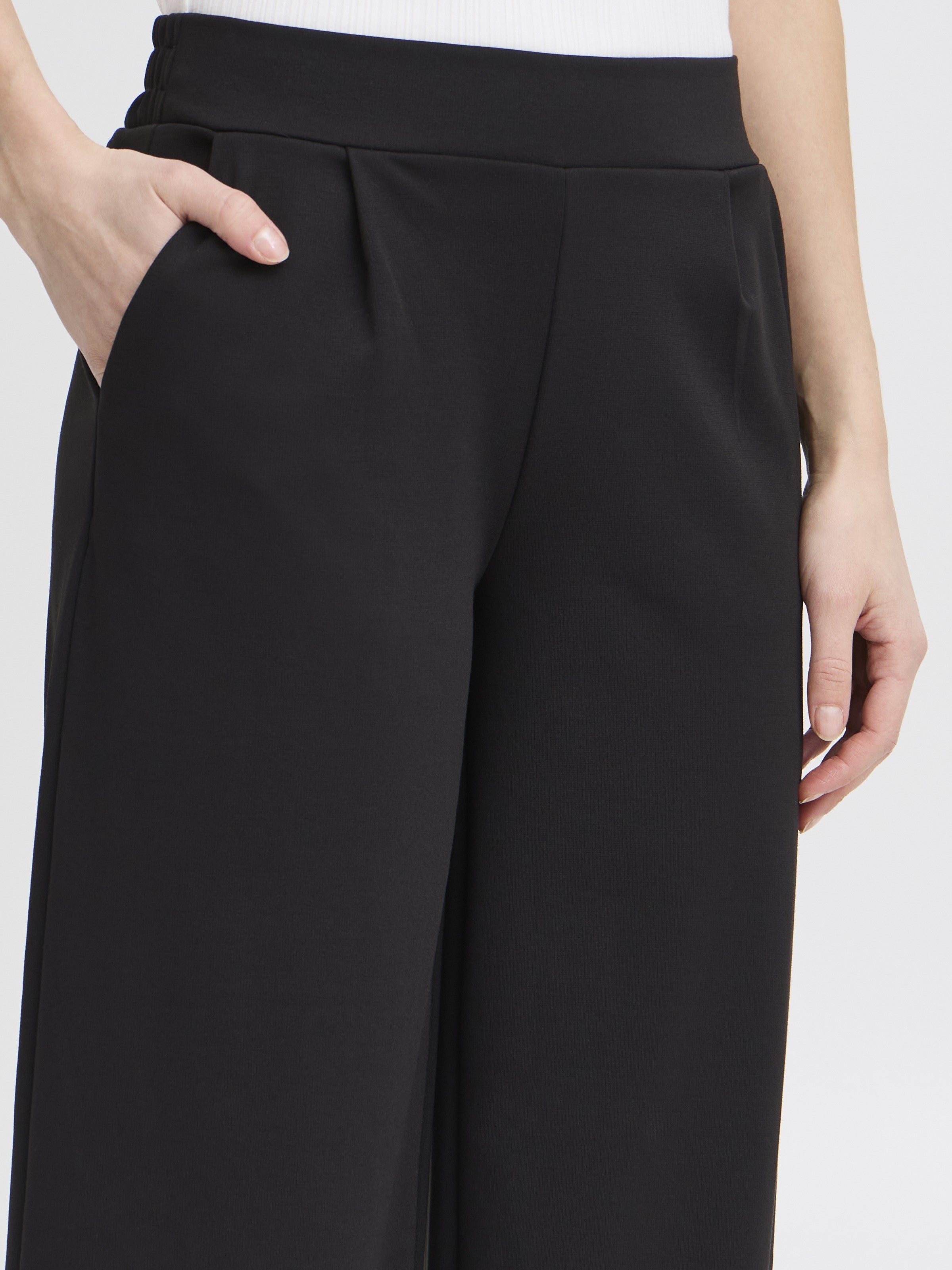 Close-up of black Ichi Kate Jersey 25” Wide Pant with side pockets and relaxed fit on model.