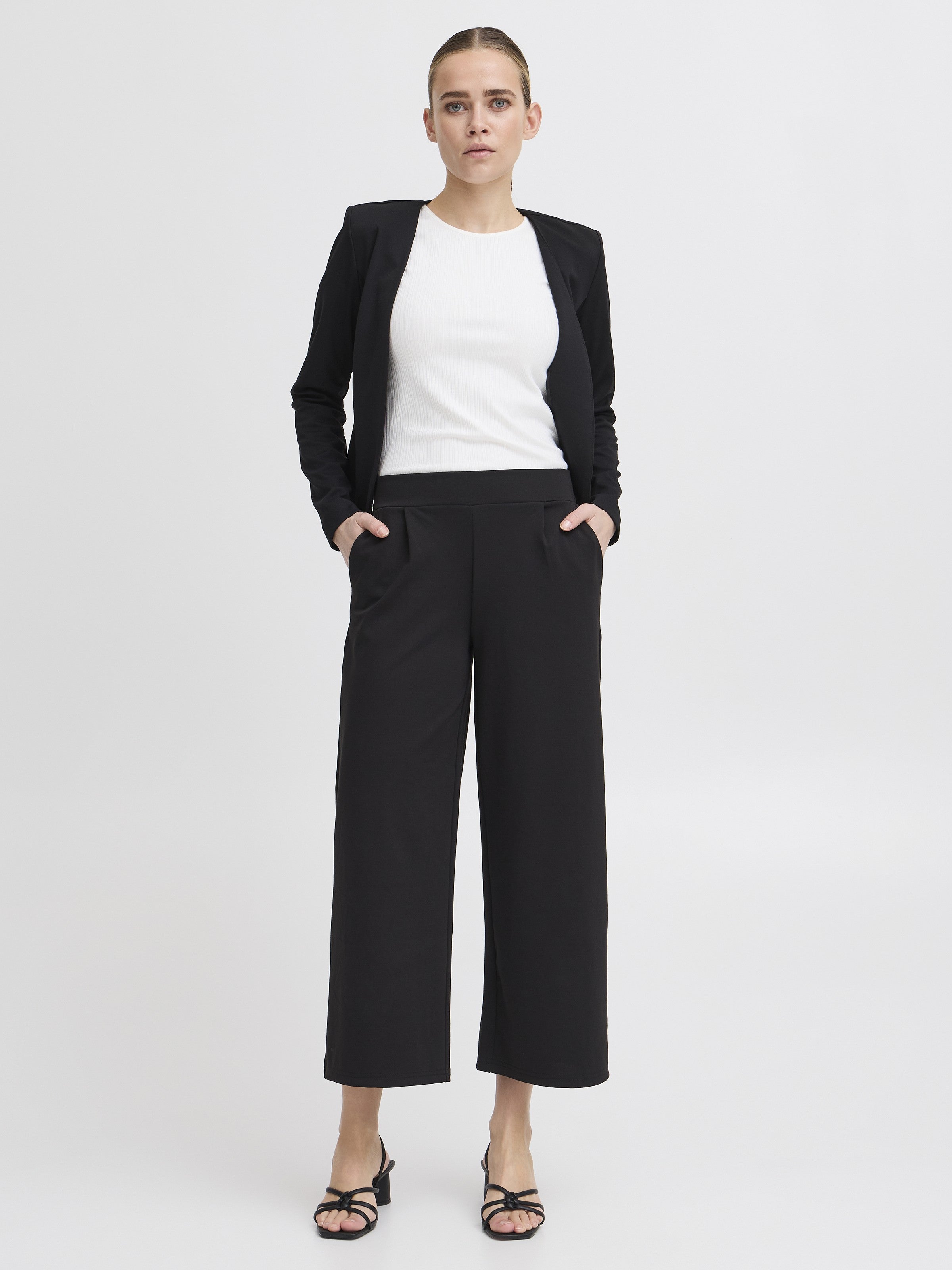 Model wearing Ichi Kate Jersey 25” Wide Pant in black with a black blazer and white top by Ichi.