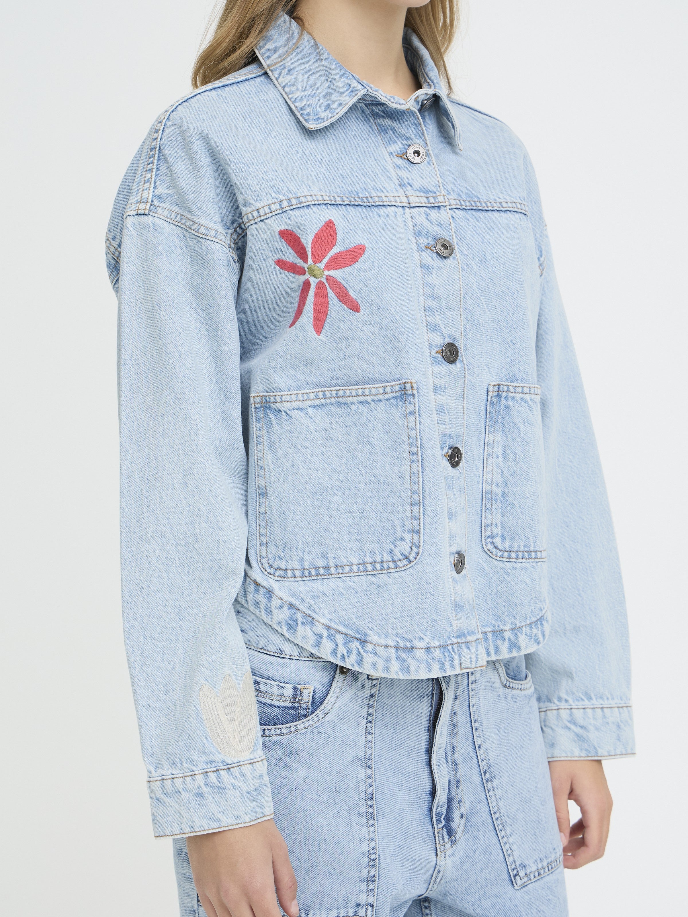 Ichi Bauve Flower Denim Jacket in light blue with floral embroidery and front pockets, styled as casual outerwear.