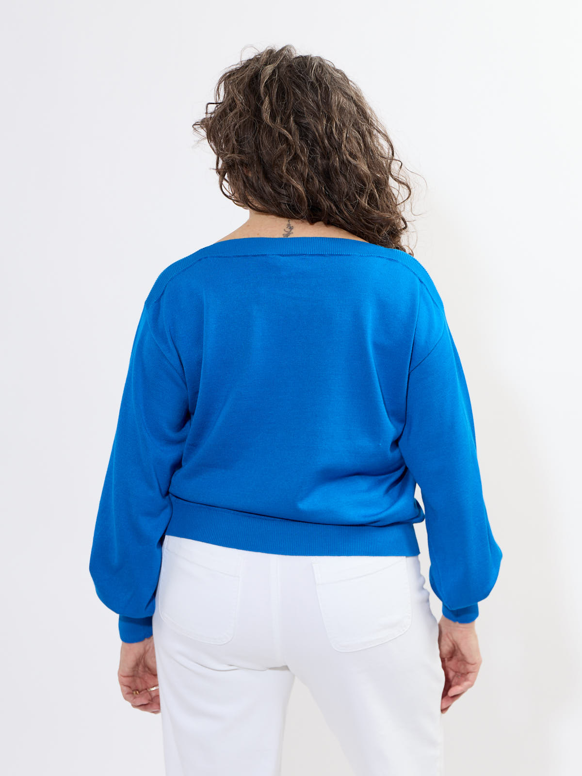 Back view of Ichi Boat Neck Sweater in vibrant blue by Ichi, styled with white pants showcasing sweater details.