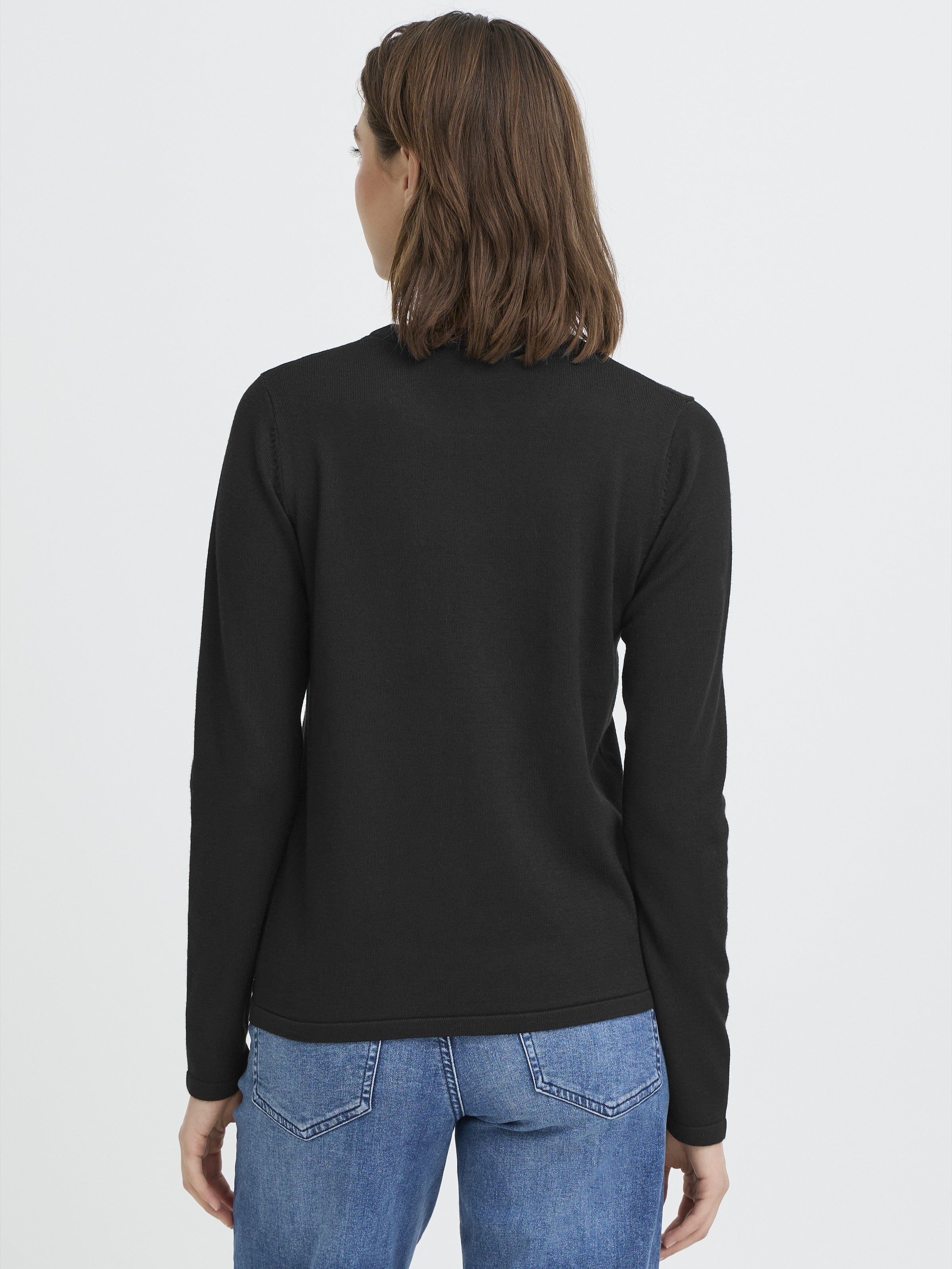 Back view of a figure in a fitted black long-sleeve top paired with blue denim jeans against a plain background.