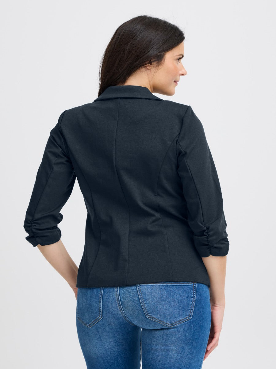 Back view of a navy Fransa Gathered Sleeve Stretch Blazer styled with casual denim jeans