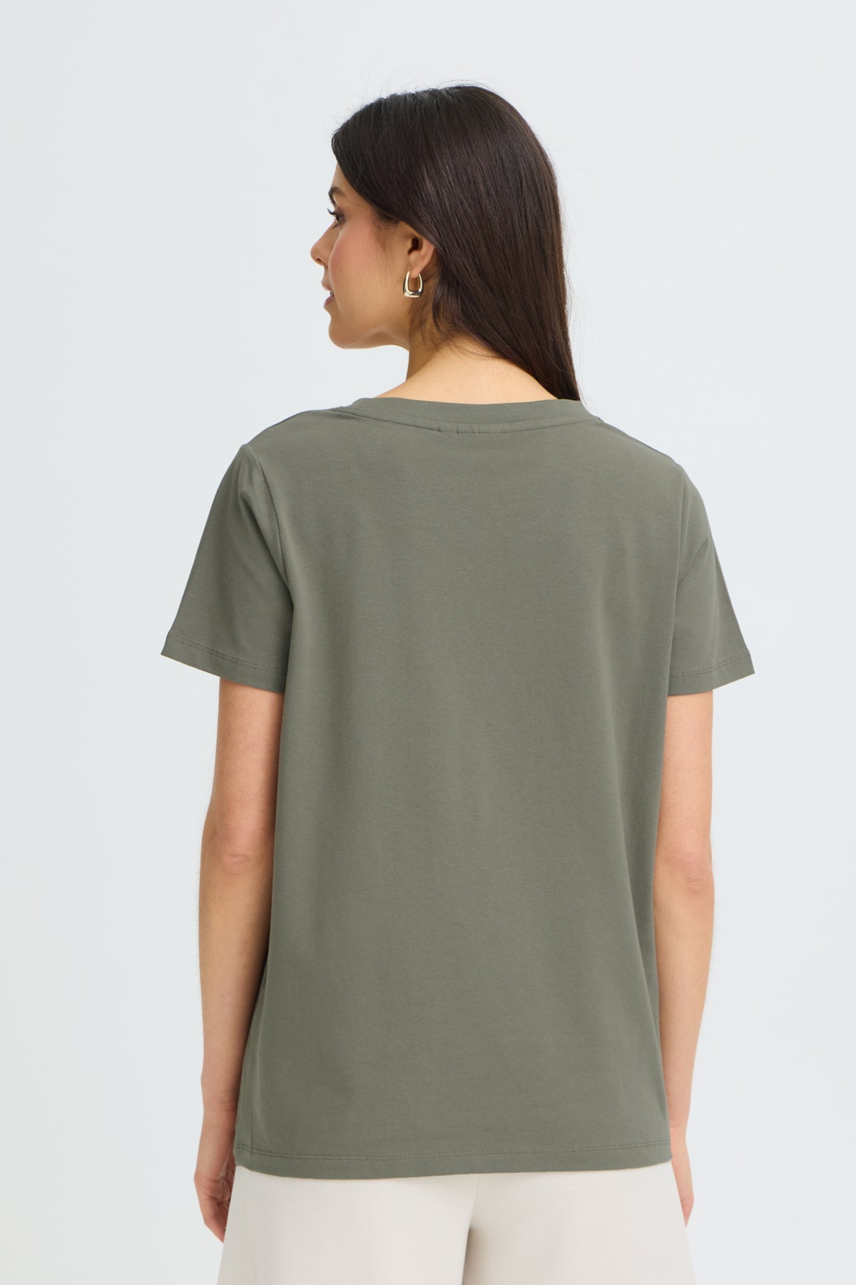 Back view of Fransa Shoulder Detail Short Sleeve Crew Neck T-Shirt in olive green, styled with light pants.