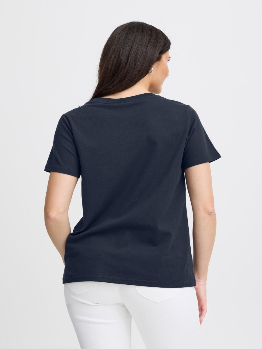 Fransa Shoulder Detail Short Sleeve Crew Neck T-Shirt in navy blue, styled with white pants, back view.