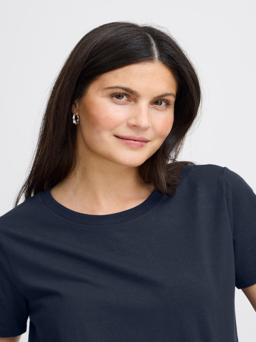 Close-up of a model wearing a navy Fransa Shoulder Detail Short Sleeve Crew Neck T-Shirt, styled simply and elegantly.