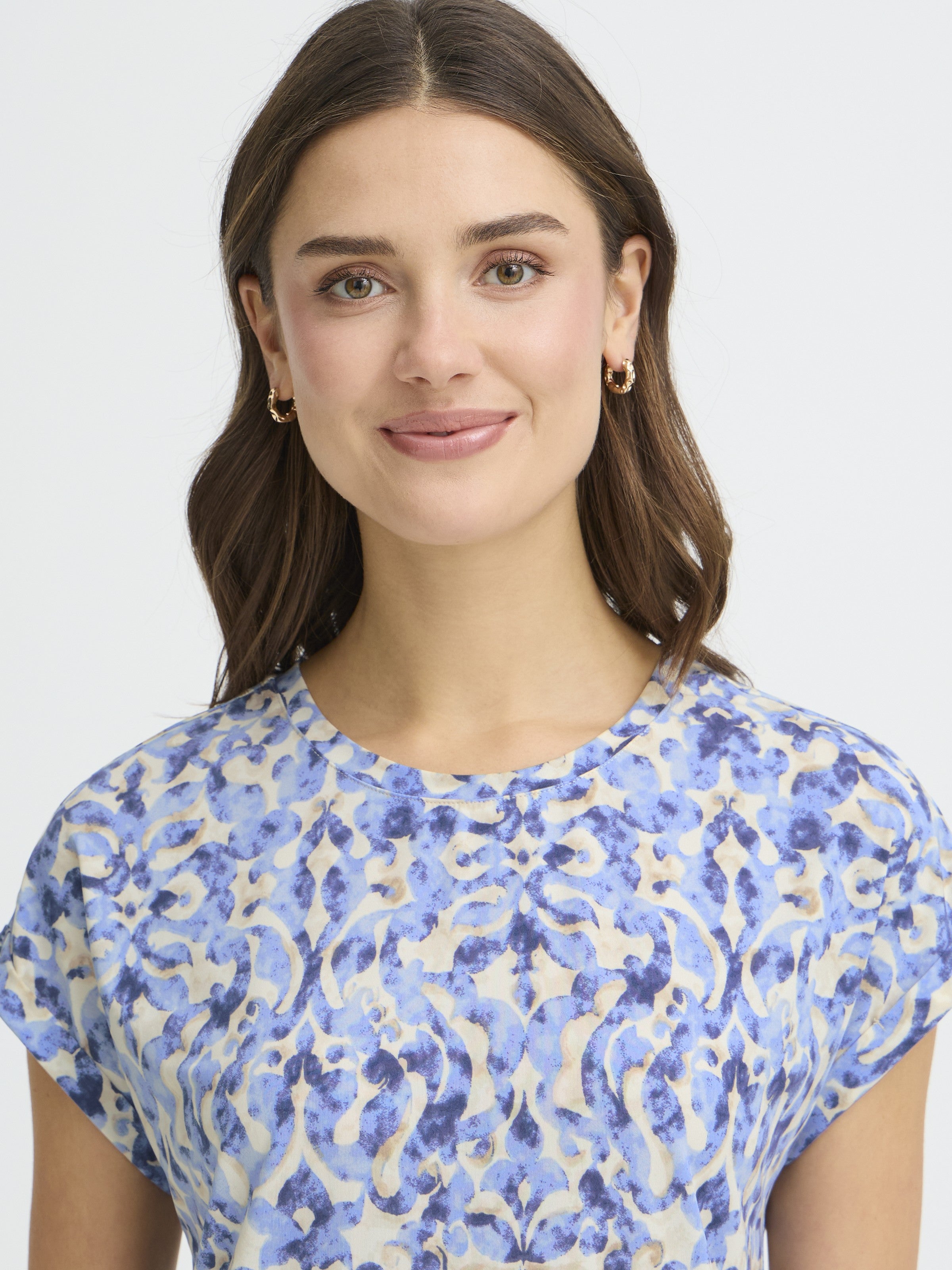 Close-up of a model wearing a blue patterned Fransa Seen Short Sleeve Crew Neck Top in a soft fabric by Fransa.