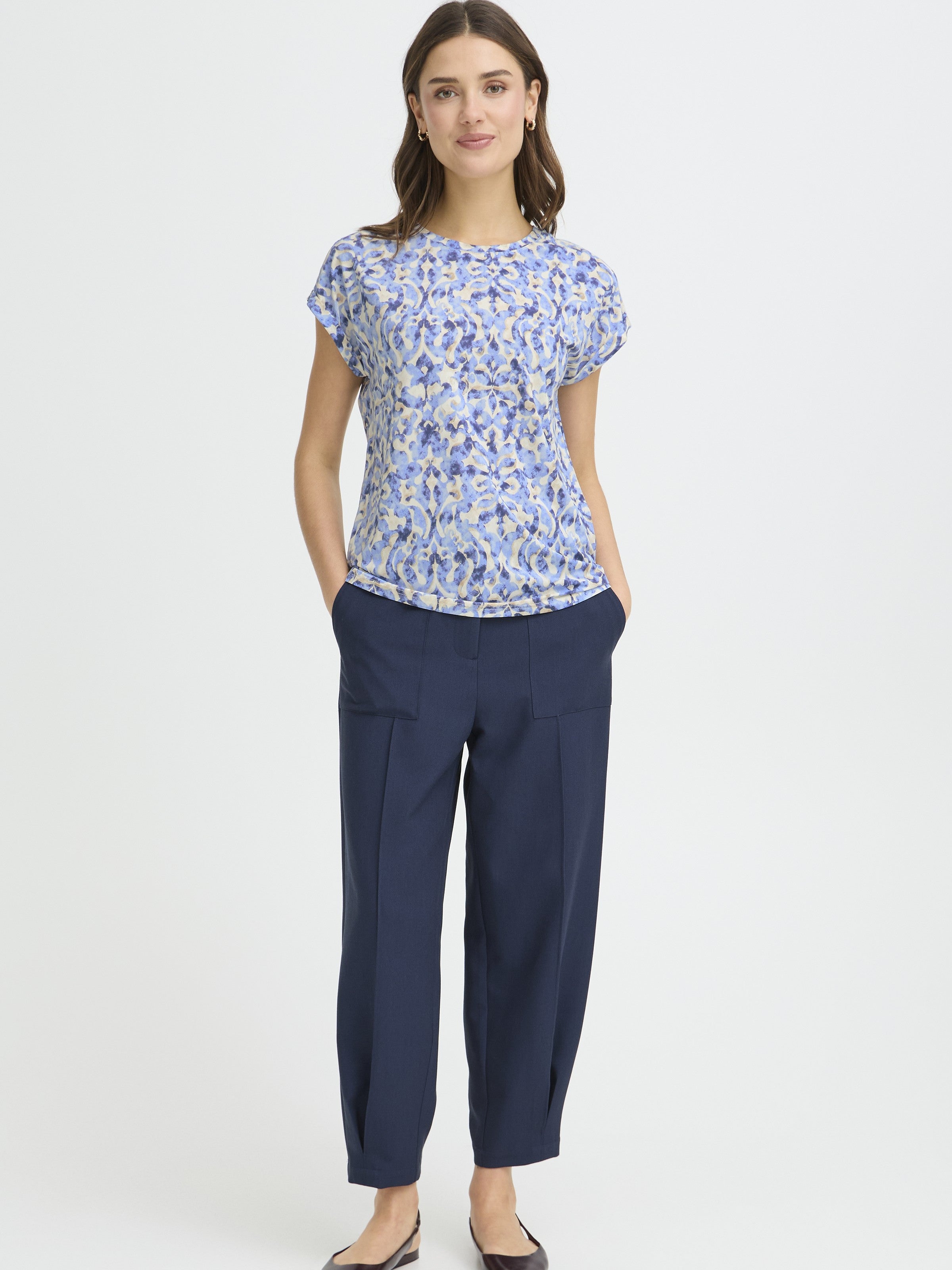 Fransa Seen Short Sleeve Crew Neck Top in blue floral pattern styled with navy trousers and simple earrings
