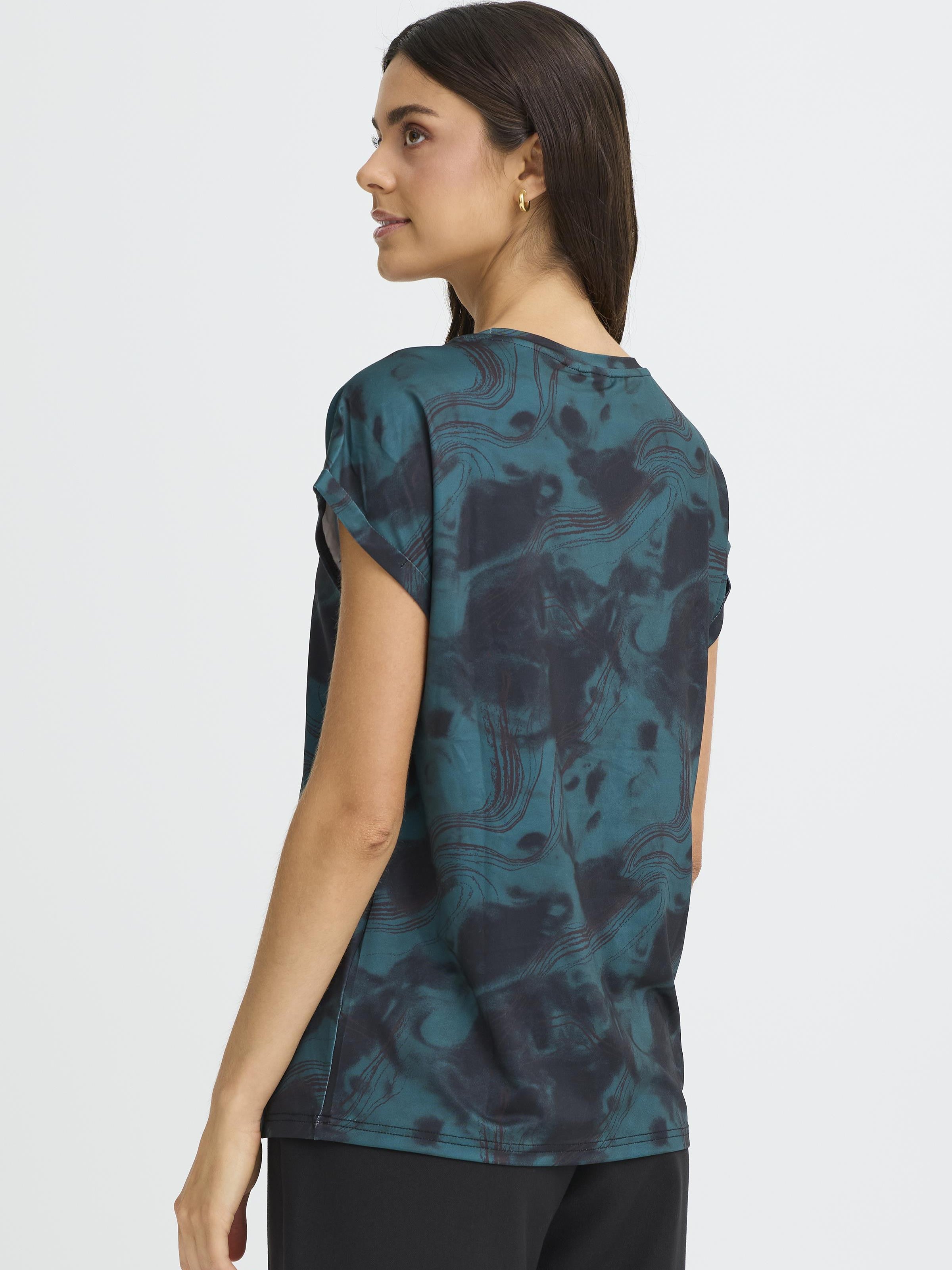 Side view of a model wearing Fransa Seen Short Sleeve Crew Neck Top in a dark green patterned design by Fransa