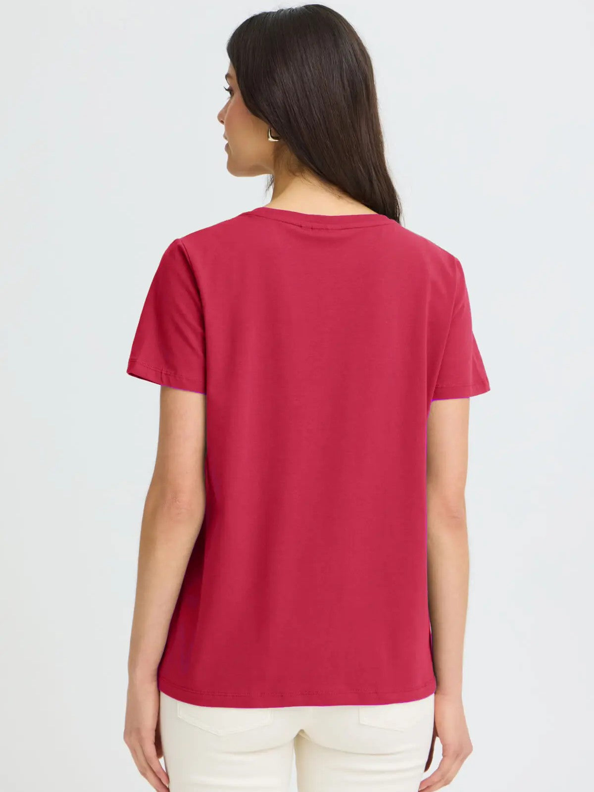Back view of a plain red short-sleeve top paired with light-colored pants against a plain background.
