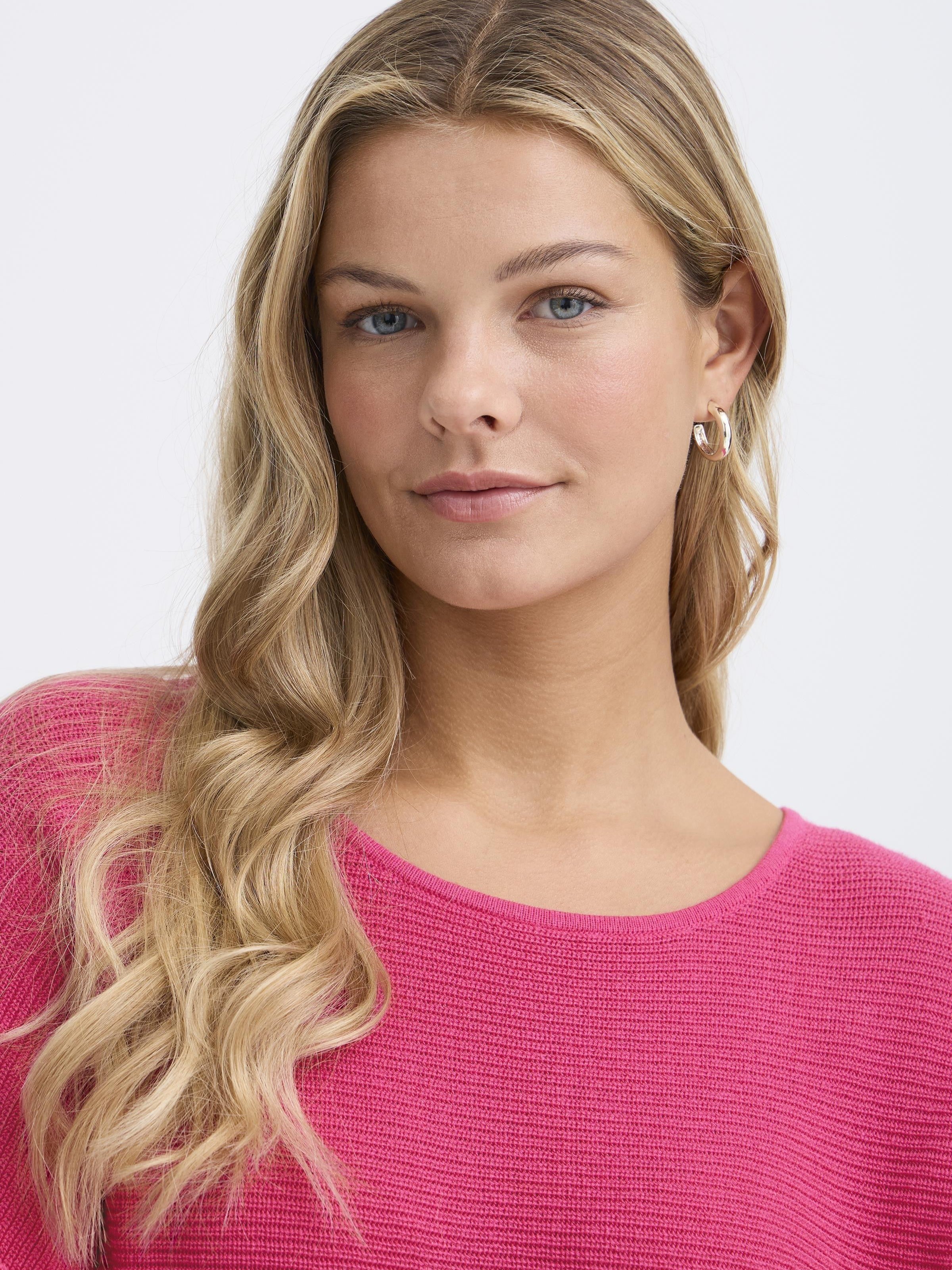Close-up of a model wearing a pink Fransa Sinja Ribbed Crew Neck Knit Top by Fransa showcasing texture and style.