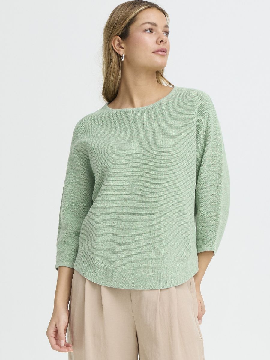 Light green ribbed crew neck knit top by Fransa Sinja worn with beige pants in a minimalist setting
