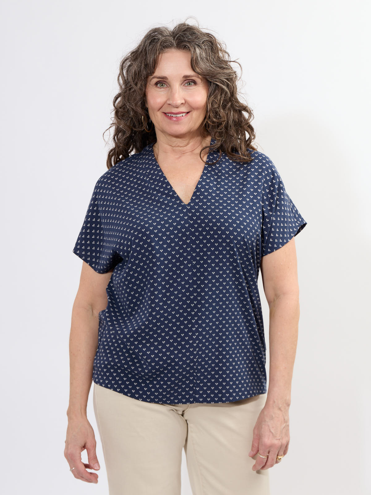 Fransa Justine Heart Print Short Sleeve V-Neck Top in navy with small heart pattern, styled casually with light pants