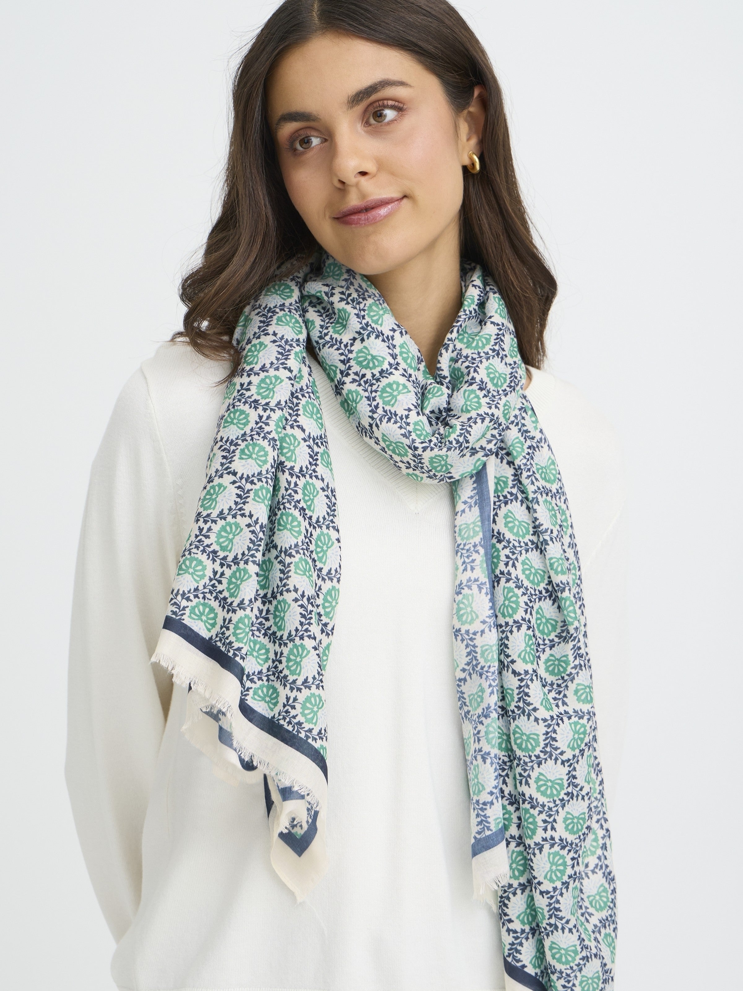 Fransa Sanni Shell Print Lightweight Scarf in navy and green worn over a white top by Fransa Accessories.