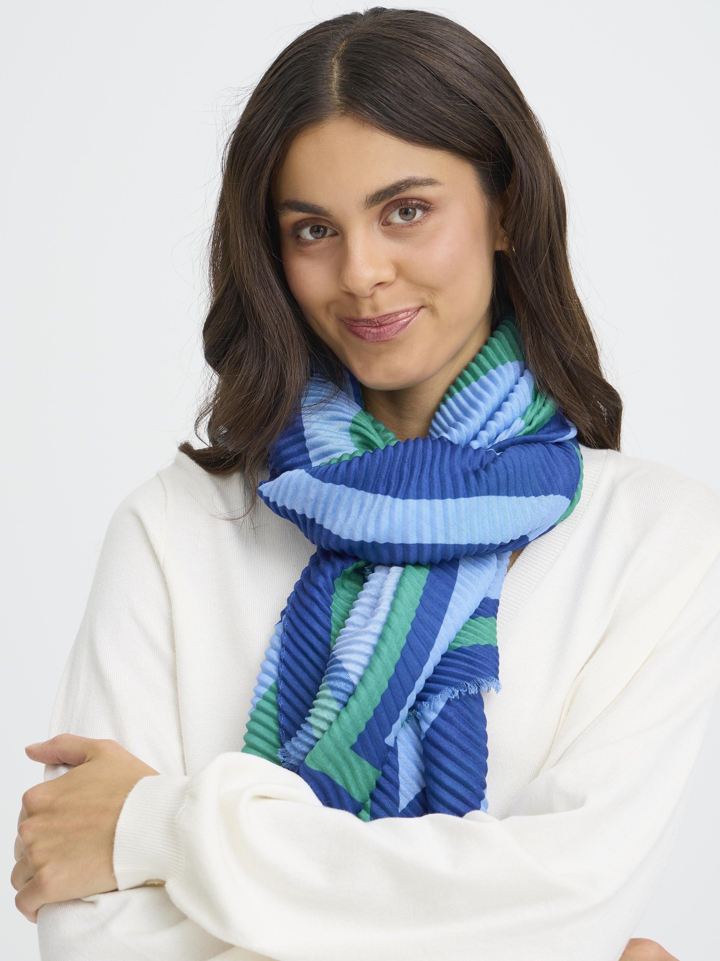 Model with dark hair wearing a blue and green striped Fransa Plisea Printed Lightweight Scarf by Fransa
