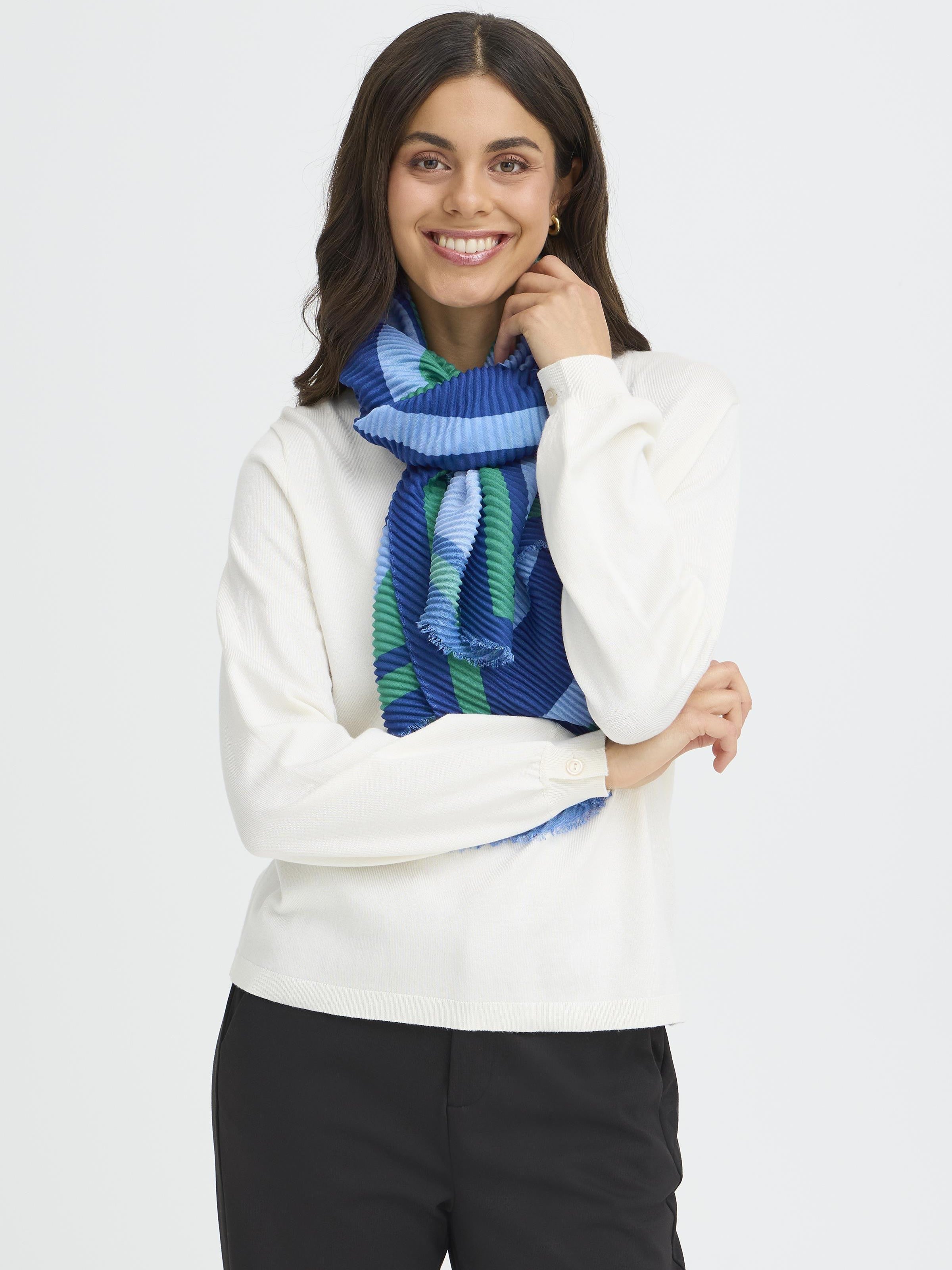 Smiling model in white top wearing a blue and green scarf styled as Fransa Plisea Printed Lightweight Scarf by Fransa accessories