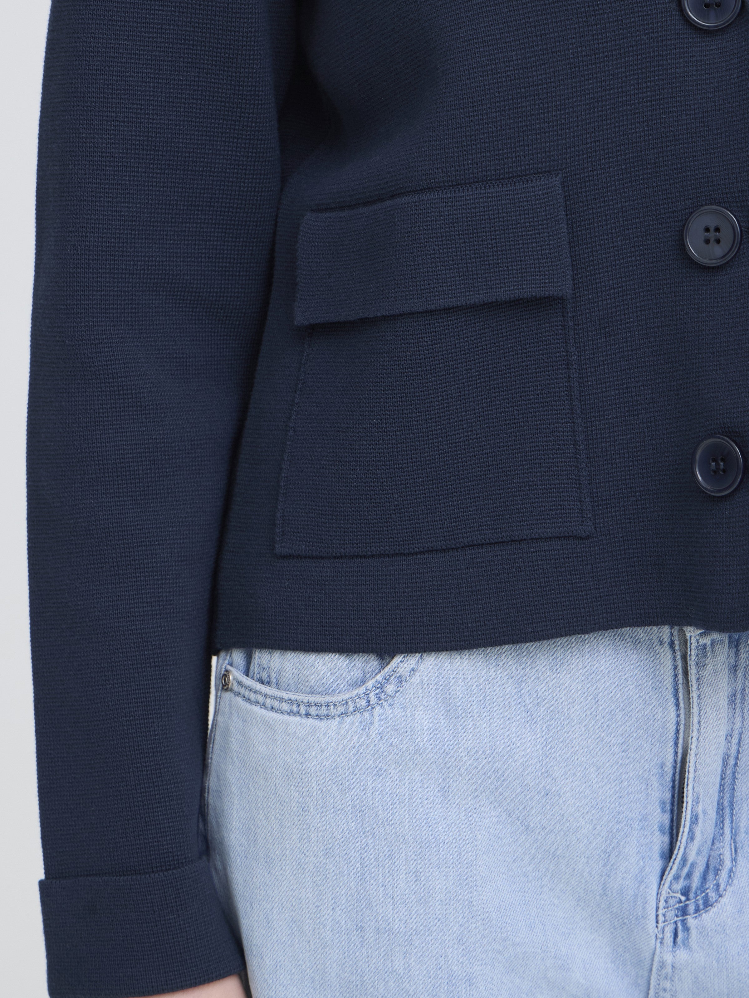 Close-up of navy Fransa Frita Three-Button Pocket Cardigan showing textured fabric and front pocket detail by Fransa.