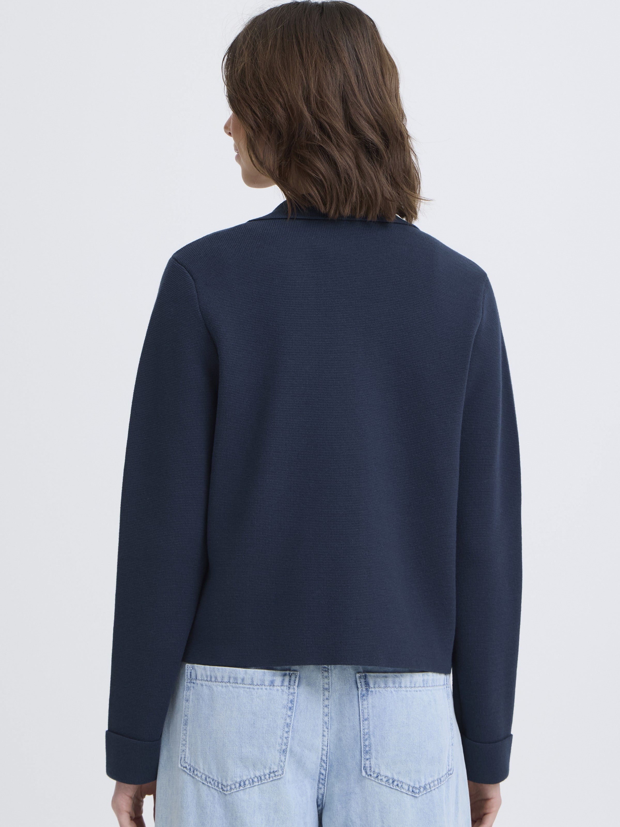 Back view of Fransa Frita Three-Button Pocket Cardigan in navy blue by Fransa, styled with light denim jeans.