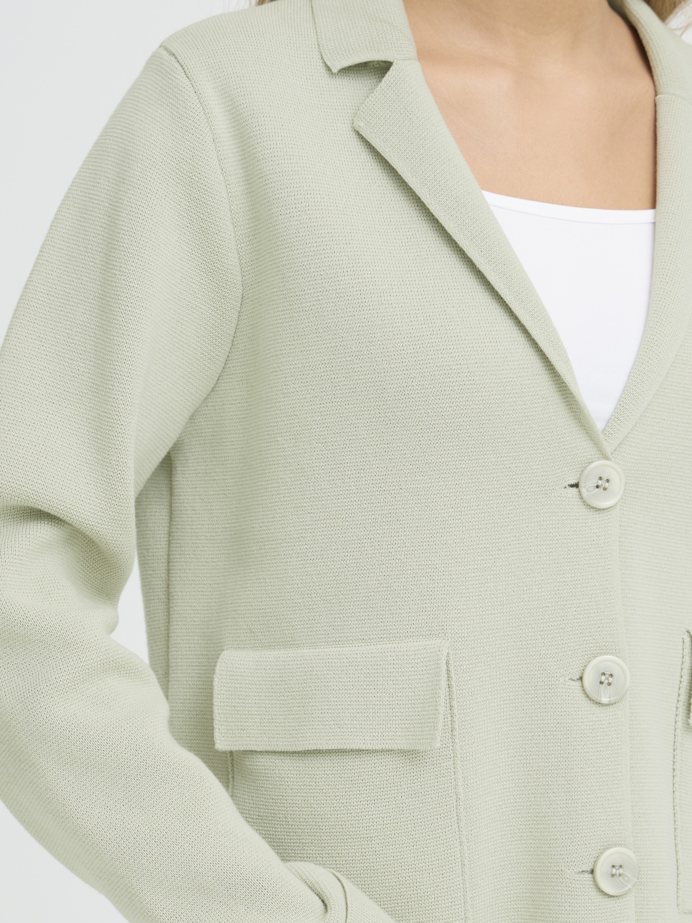 Close-up of Fransa Frita Three-Button Pocket Cardigan in sage green knit sweater from Fransa's outerwear collection.