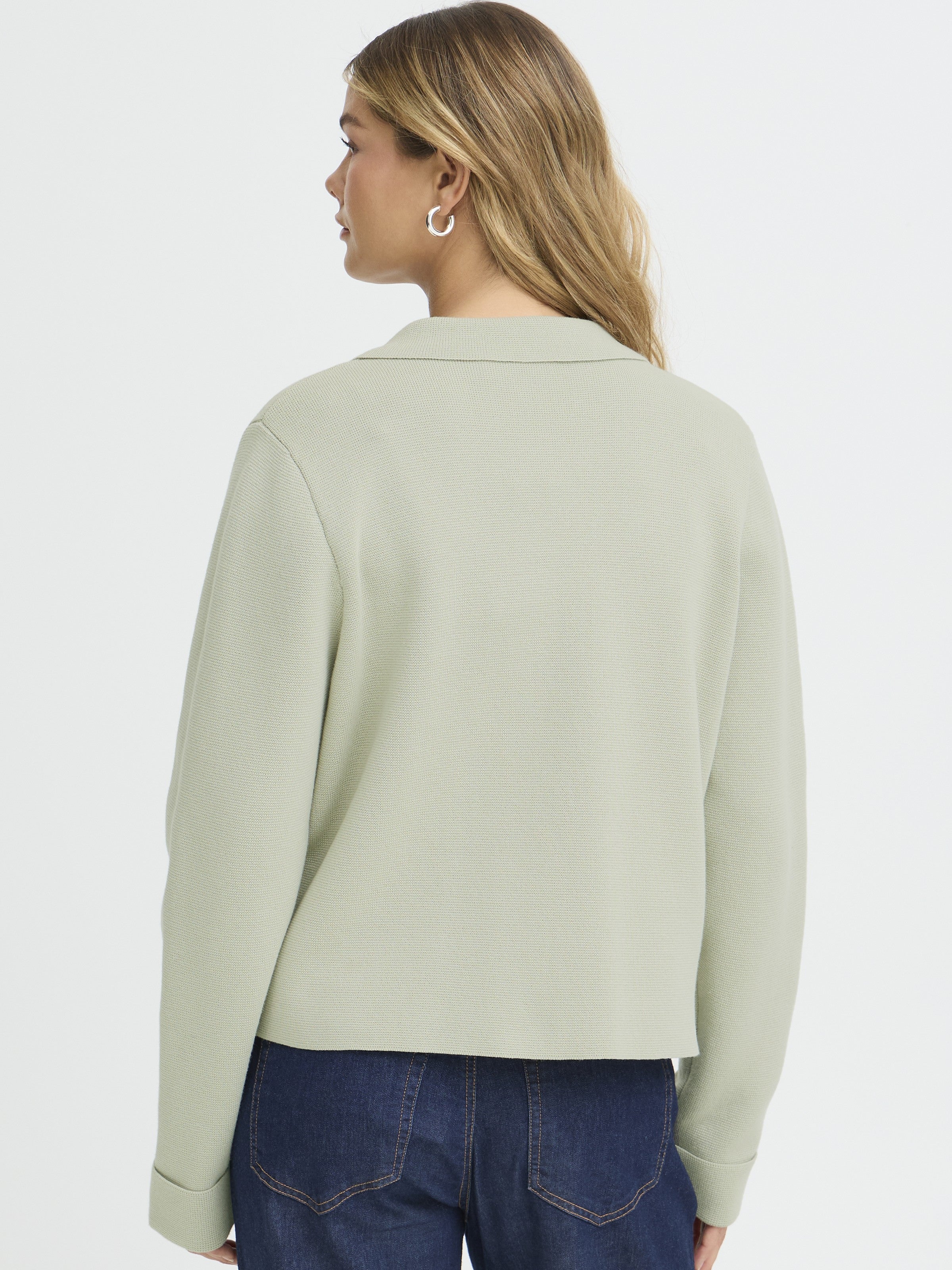 Back view of Fransa Frita Three-Button Pocket Cardigan in sage green, styled with dark denim jeans by Fransa