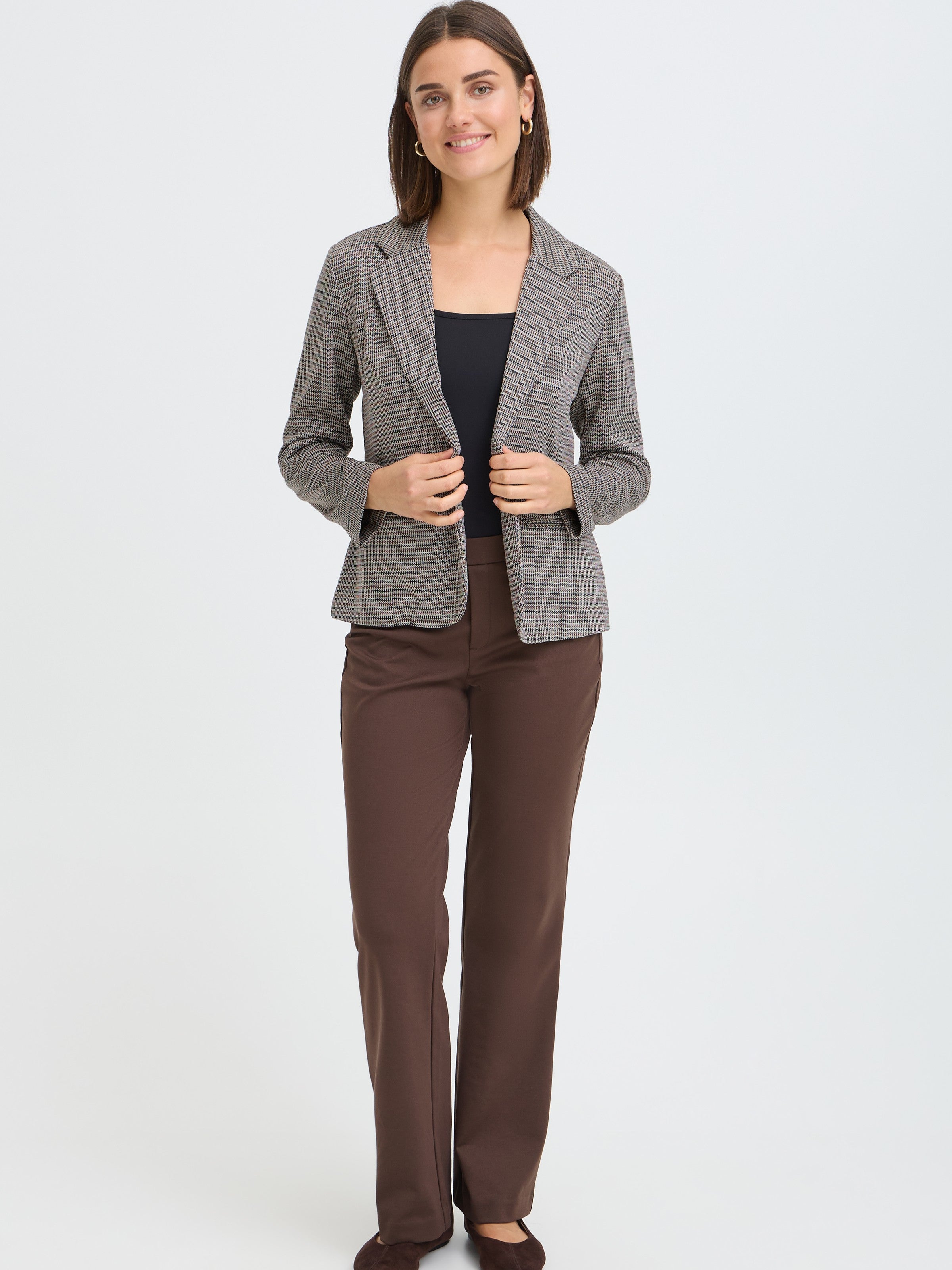 Slim fit checked blazer paired with a black top and brown straight-leg pants against a plain background.