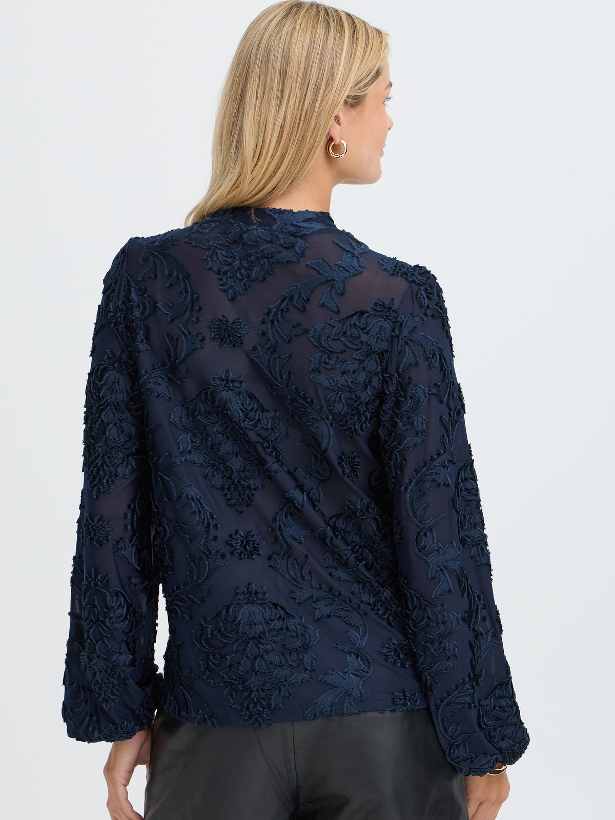 Back view of a navy floral embroidered jacket with long sleeves and textured detailing