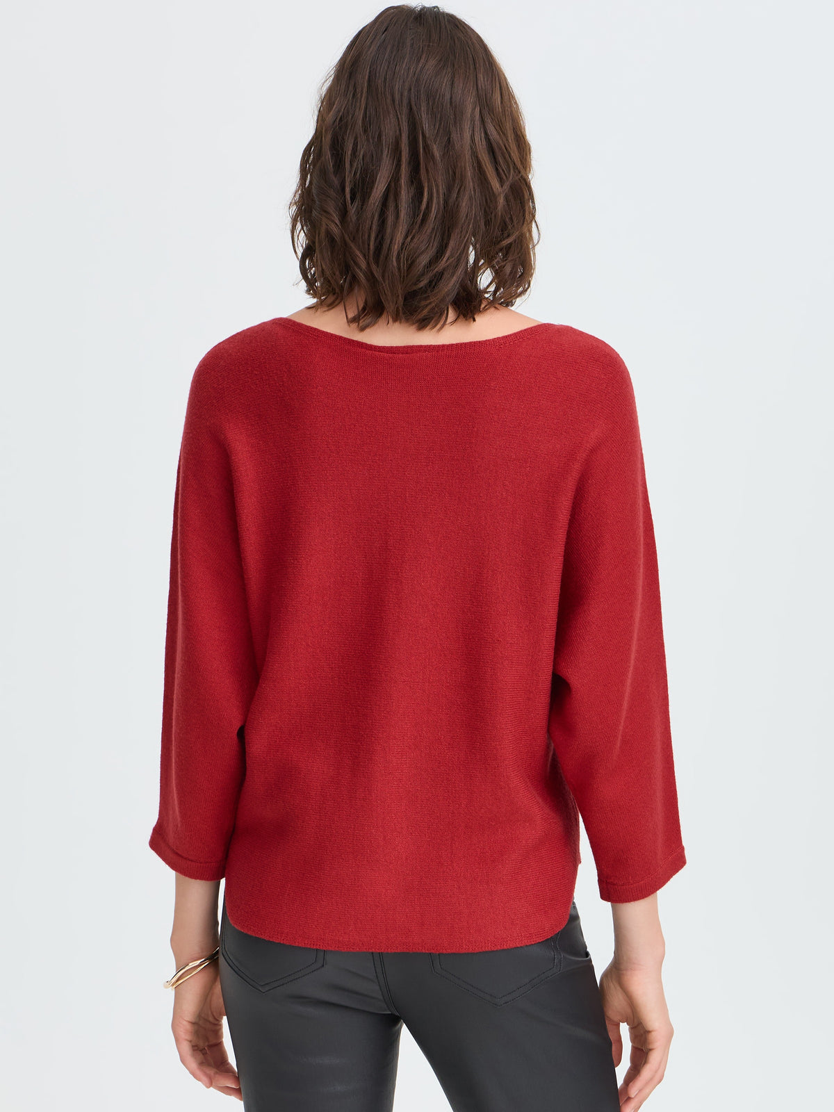 Back view of a red sweater with rolled sleeves and black pants