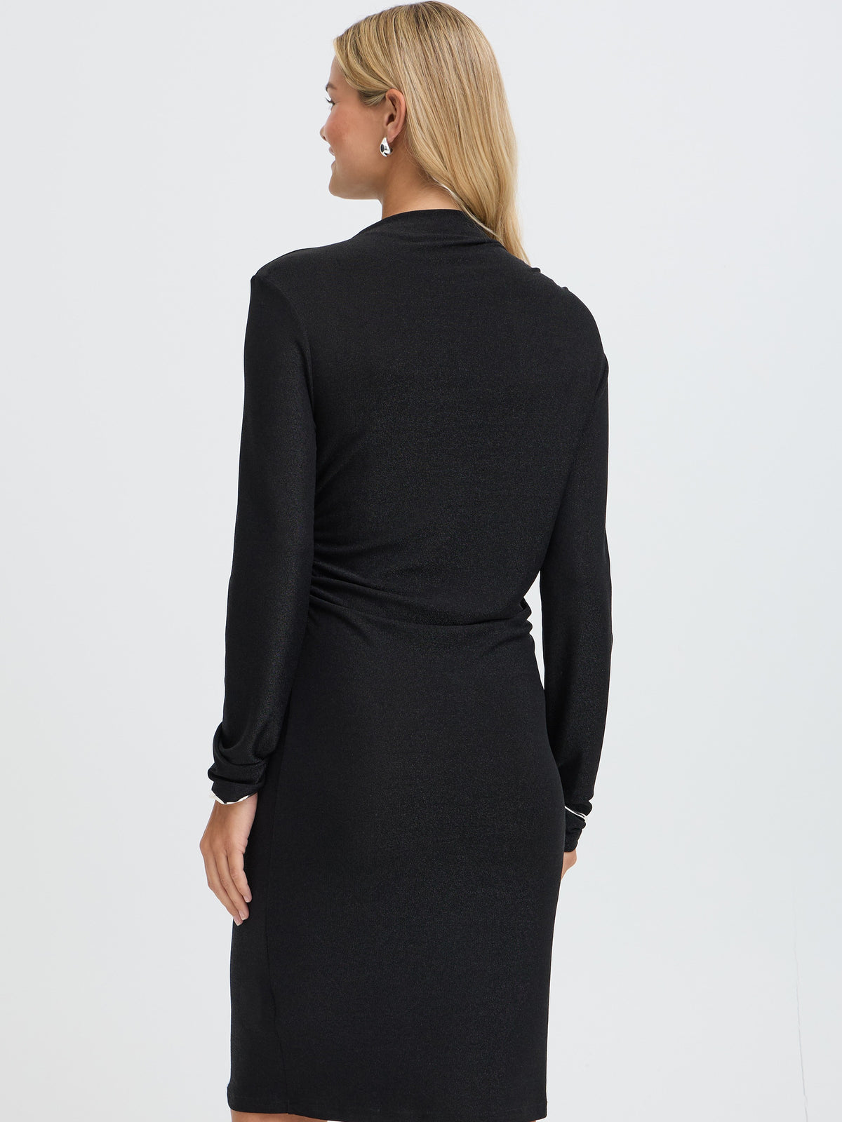 Back view of a blonde model in a black long sleeve dress with a fitted silhouette