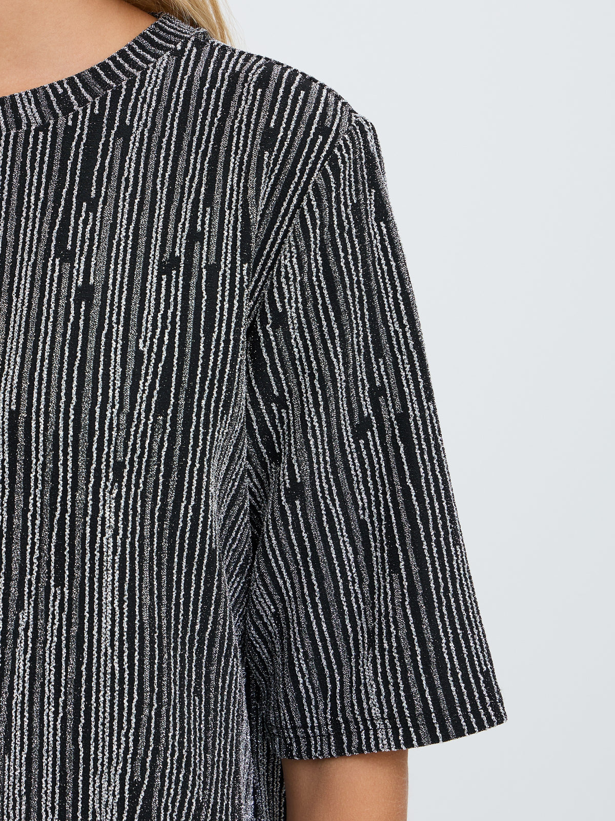 Black and gray striped knit top with a round neckline and short sleeves