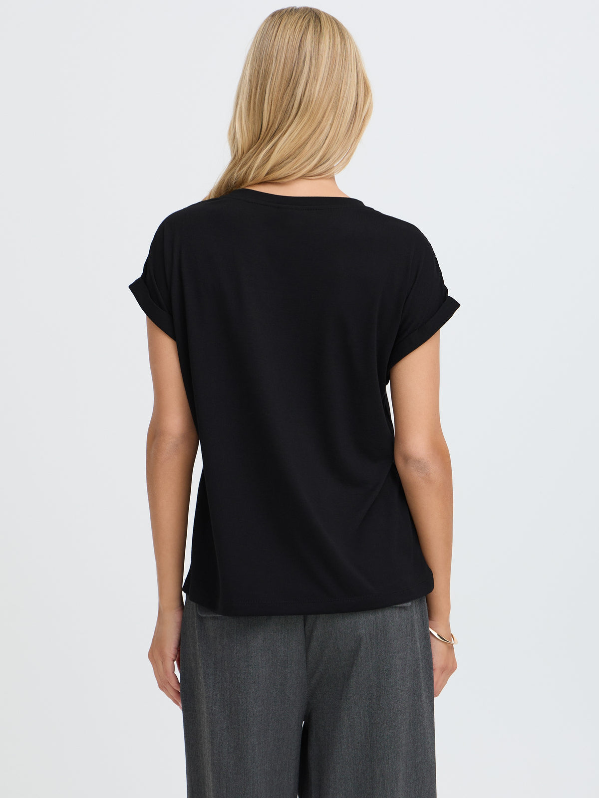 Back view of a black short-sleeve top with gray trousers
