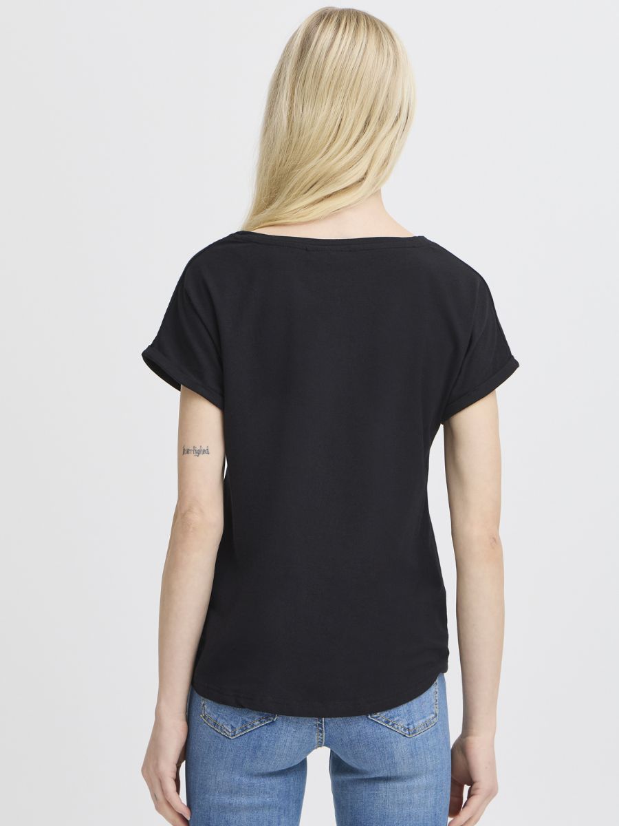 Back view of a person with long blonde hair wearing a black short-sleeve top and blue denim jeans against a plain background.