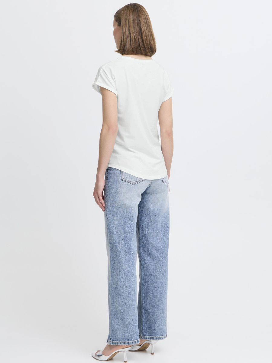 Person facing away wearing a white short-sleeve top and light blue straight-leg denim jeans with heels