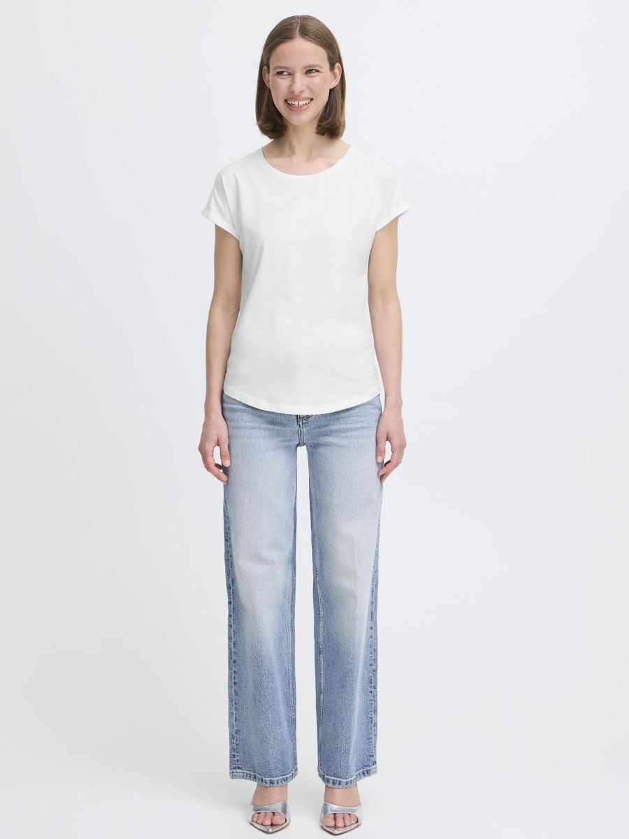 Person standing in a white short-sleeve top and light blue straight-leg denim jeans against a white background