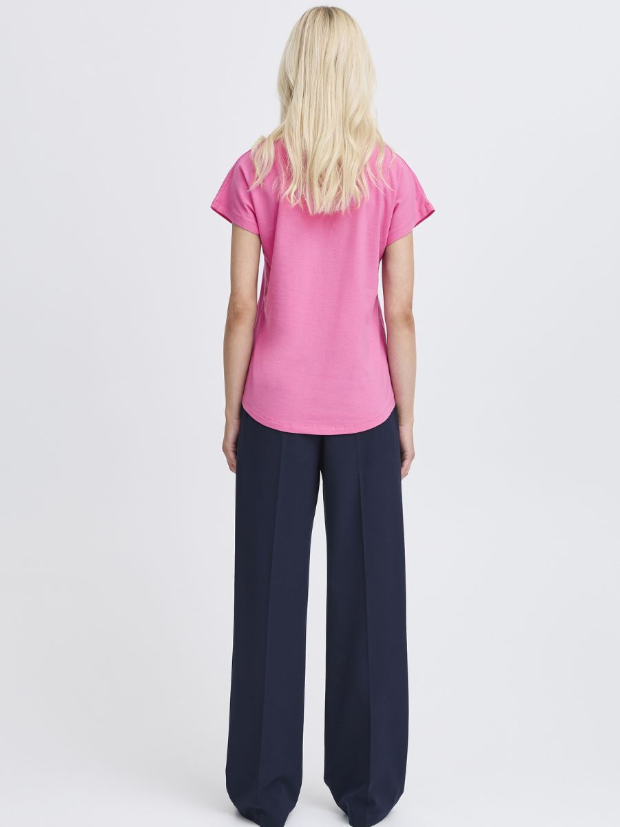 Back view of a model in B. Young Pamila V-Neck Short Sleeve Tee in pink paired with dark wide-leg pants by B. Young