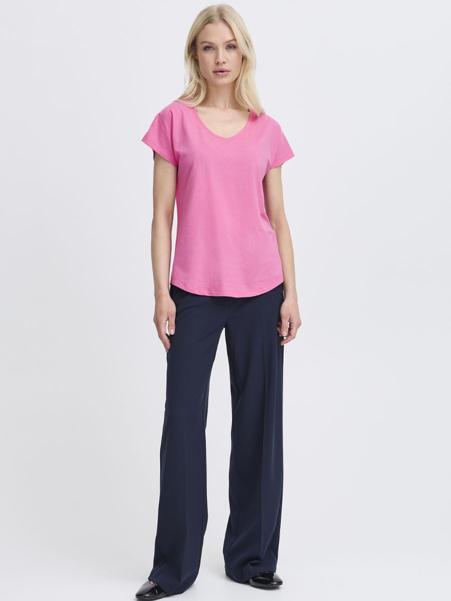 B. Young Pamila V-Neck Short Sleeve Tee in pink worn with navy pants by B. Young in a simple studio setting