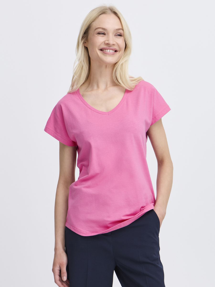 B. Young Pamila V-Neck Short Sleeve Tee in pink worn with dark pants by B. Young model smiling confidently