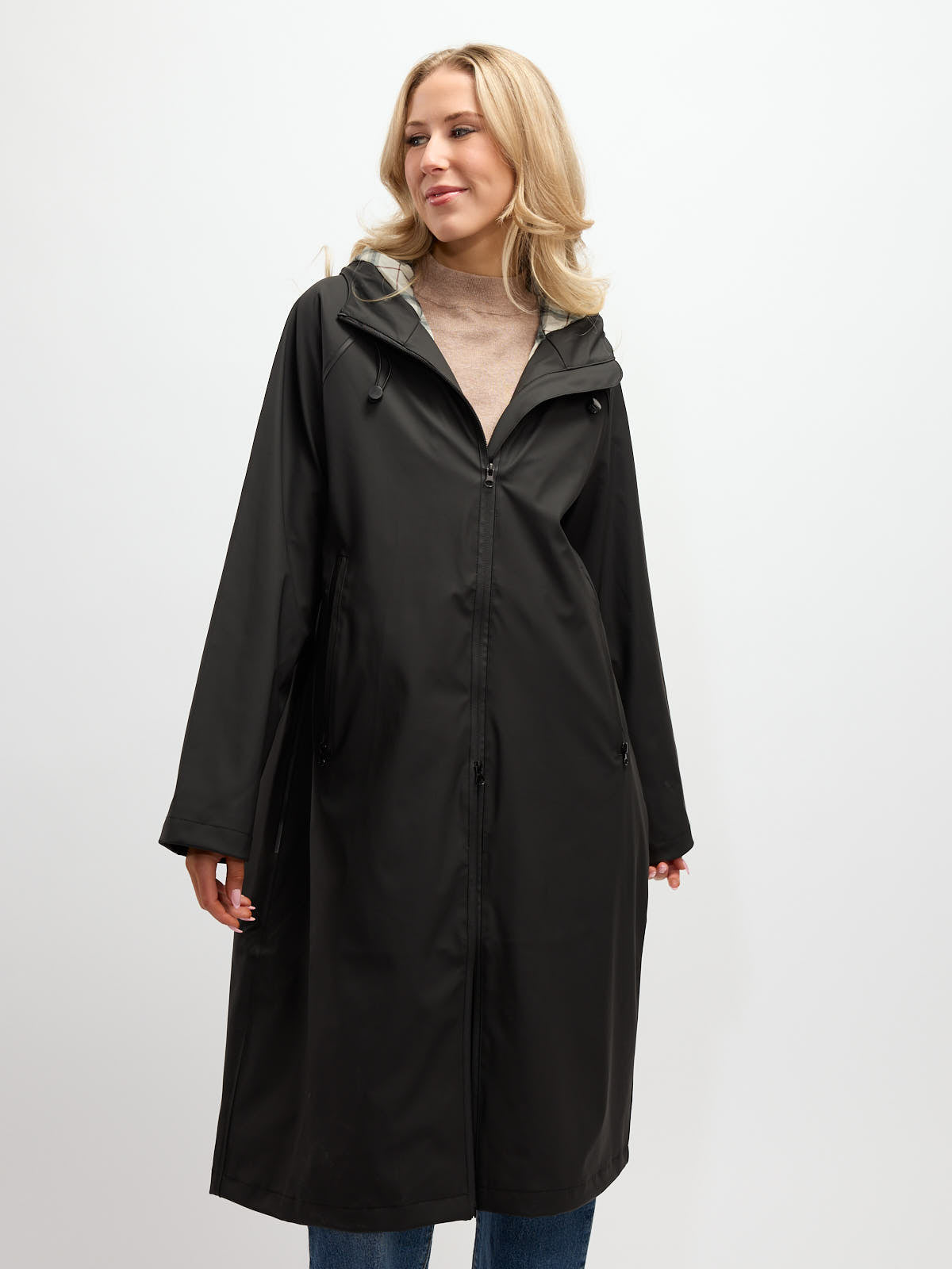 Black long rain coat with hood by B. Young featuring zipper front and side pockets, styled over casual wear.