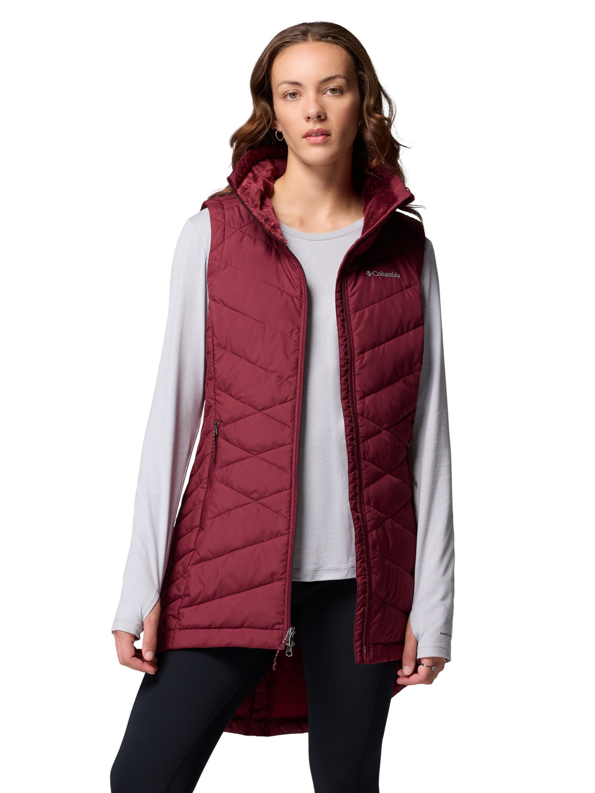 Columbia Heavenly II Omni-Heat Long Vest in wine red worn over a light gray long-sleeve top with black leggings
