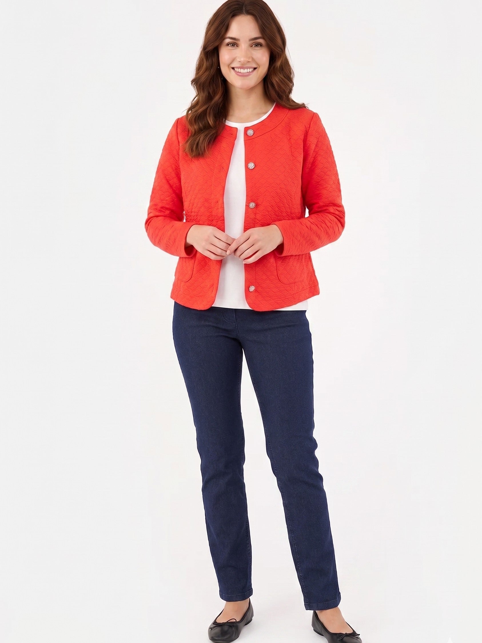 Red button-up quilted jacket paired with dark blue denim pants and black flats on a white background