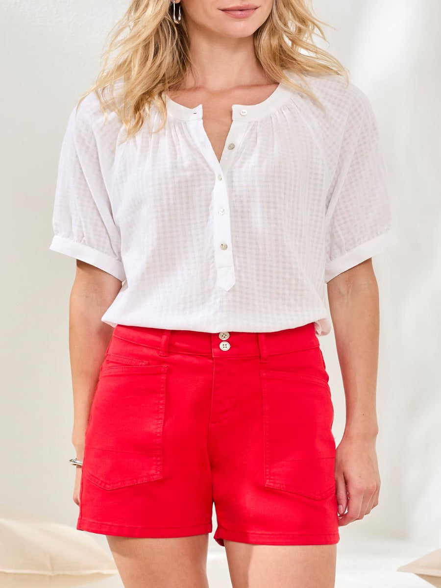 Tribal Essential 5" Colored Denim Pocket Shorts in bright red by Tribal Sportswear Inc. styled with a white blouse