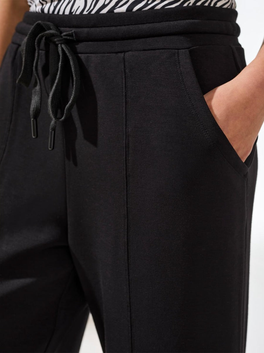 Close-up of black Tribal Techno Lux Tie-Waist Crop 26" Pants with drawstring and side pocket by Tribal Sportswear Inc.