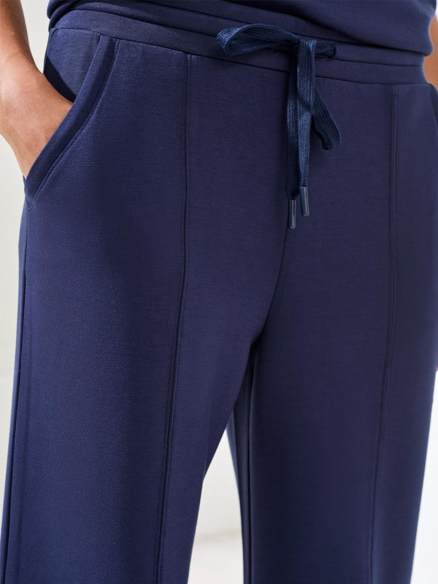 Close-up of navy blue Tribal Techno Lux Tie-Waist Crop 26" Pants by Tribal Sportswear Inc. with side pockets and drawstring waistband