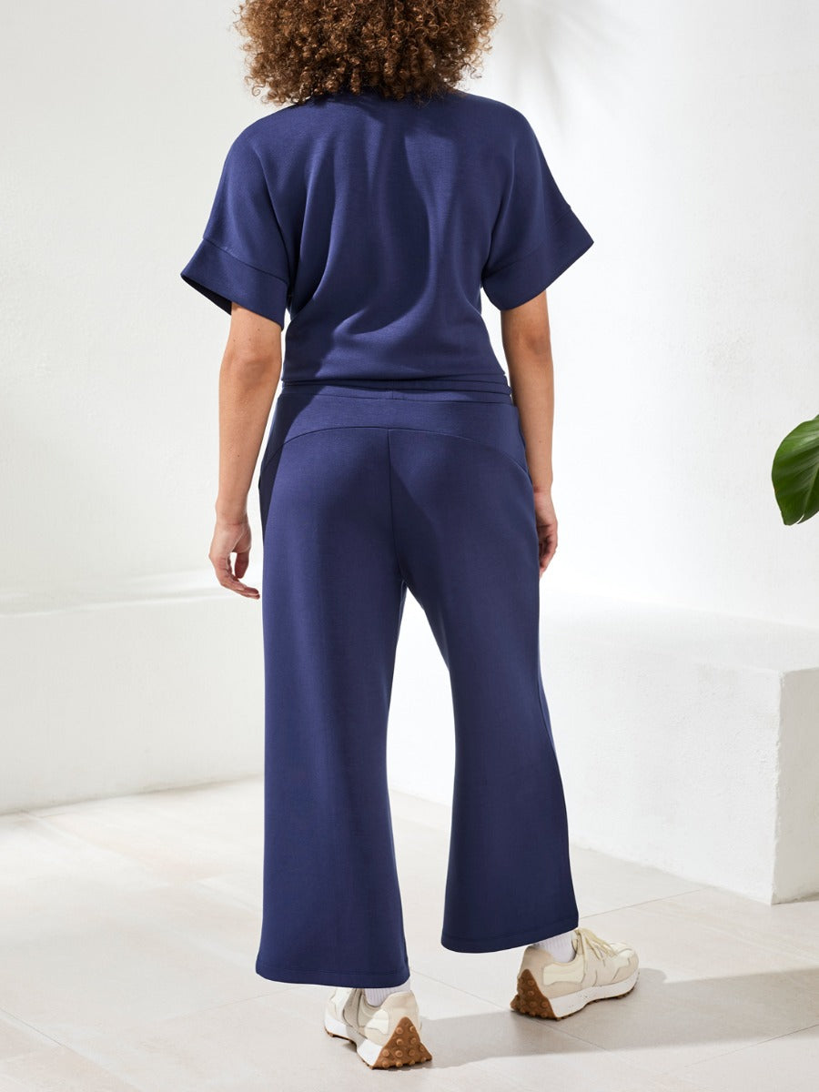 Back view of navy Tribal Techno Lux Tie-Waist Crop 26" Pants by Tribal Sportswear Inc. styled with casual top.