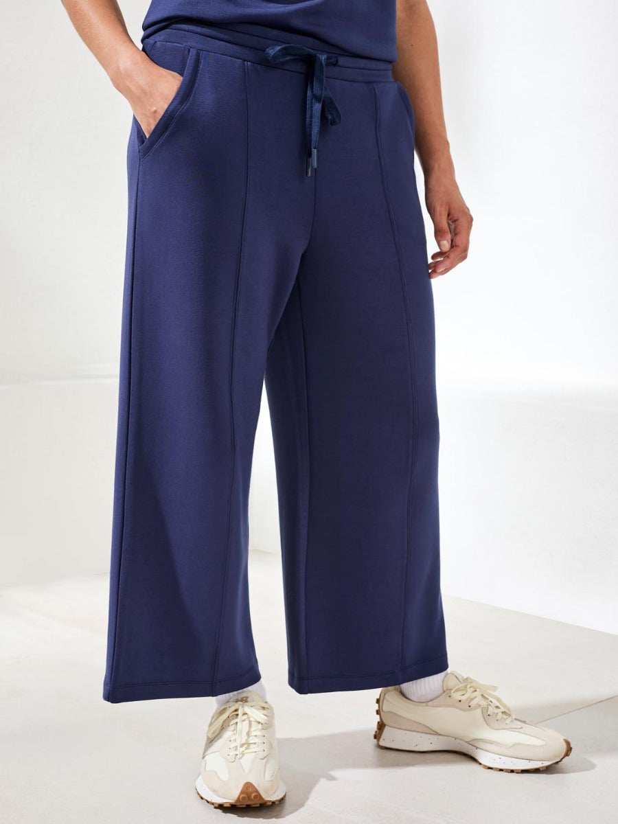 Navy blue Tribal Techno Lux Tie-Waist Crop 26" Pants by Tribal Sportswear Inc. styled with casual sneakers.